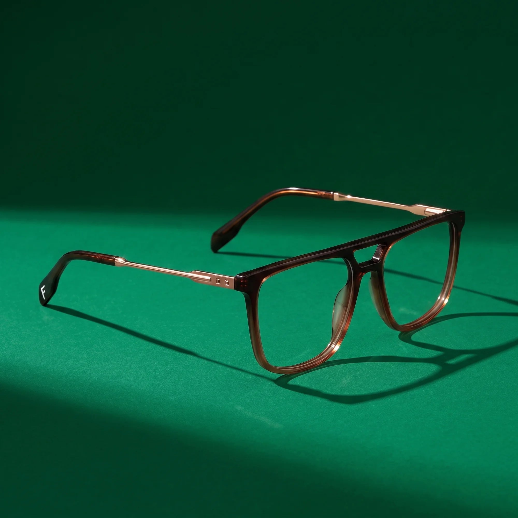 Fiore 10177 eyeglasses in brown – editorial still life on a saturated emerald set
