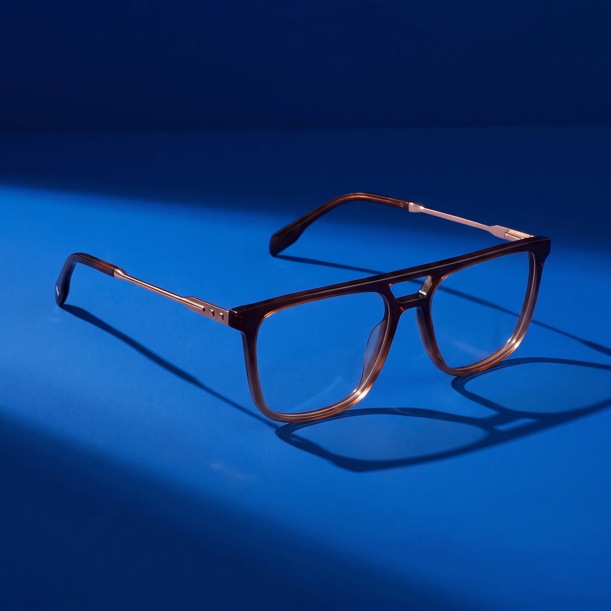 Fiore 10177 eyeglasses in brown – still life on a seamless cobalt studio backdrop