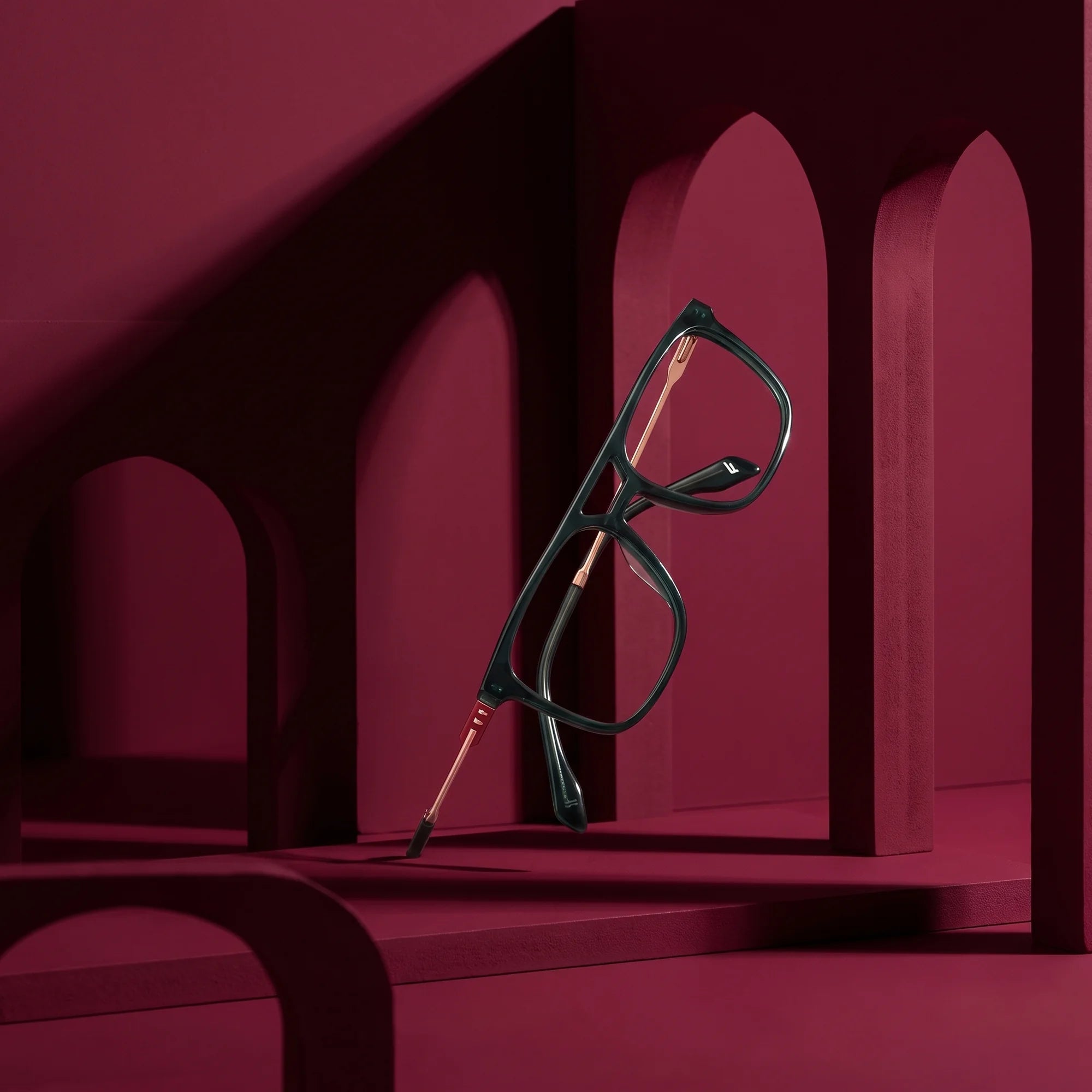 Fiore 10177 eyeglasses in green – still life among monochrome burgundy arches