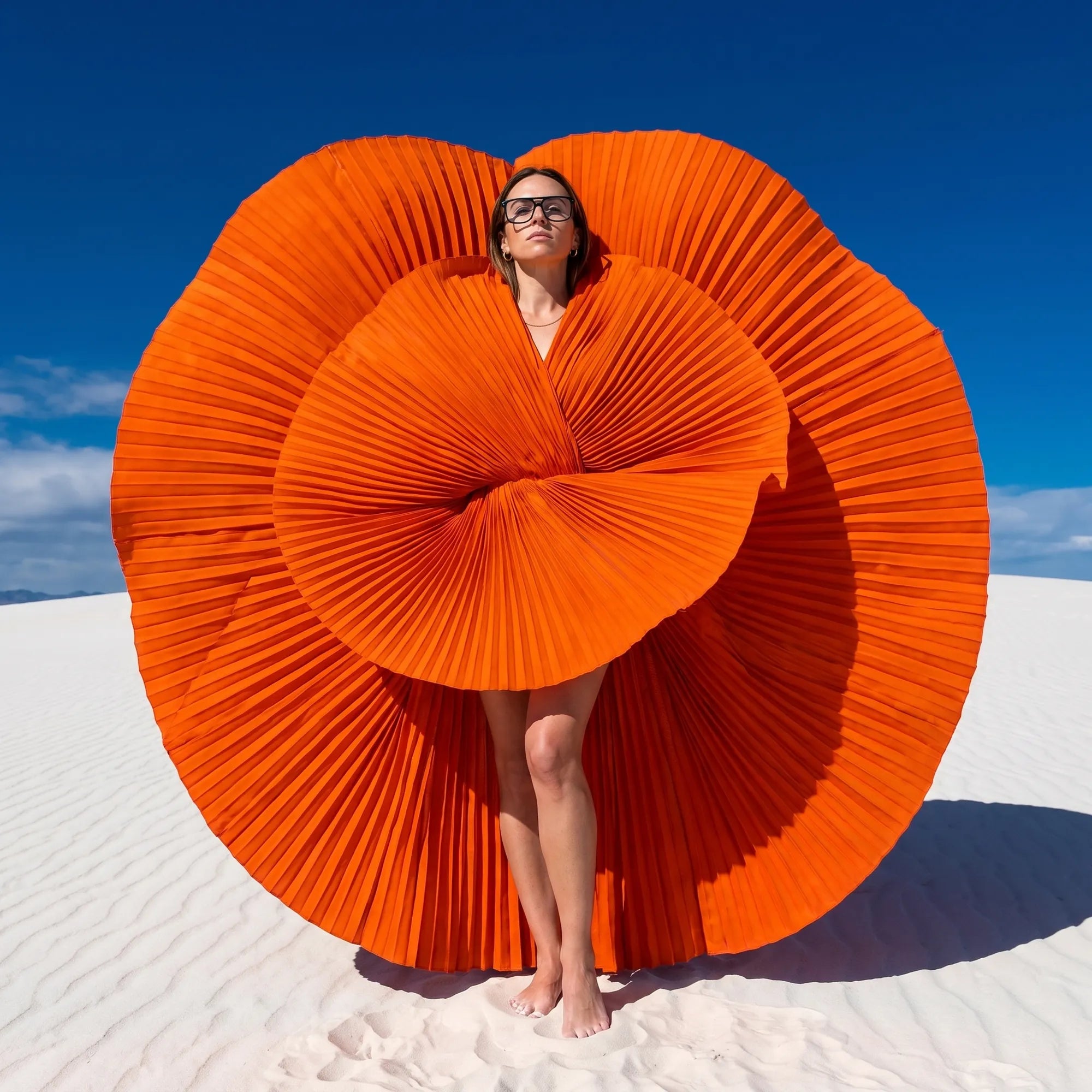 Fiore 10177 eyeglasses in green, worn by a model – campaign portrait, sculptural orange pleated fan on white dunes