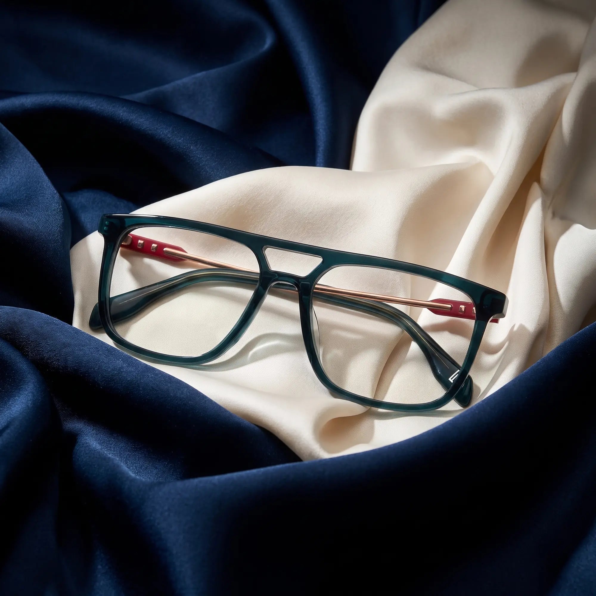 Fiore 10177 eyeglasses in green – resting on draped midnight blue and ivory silk