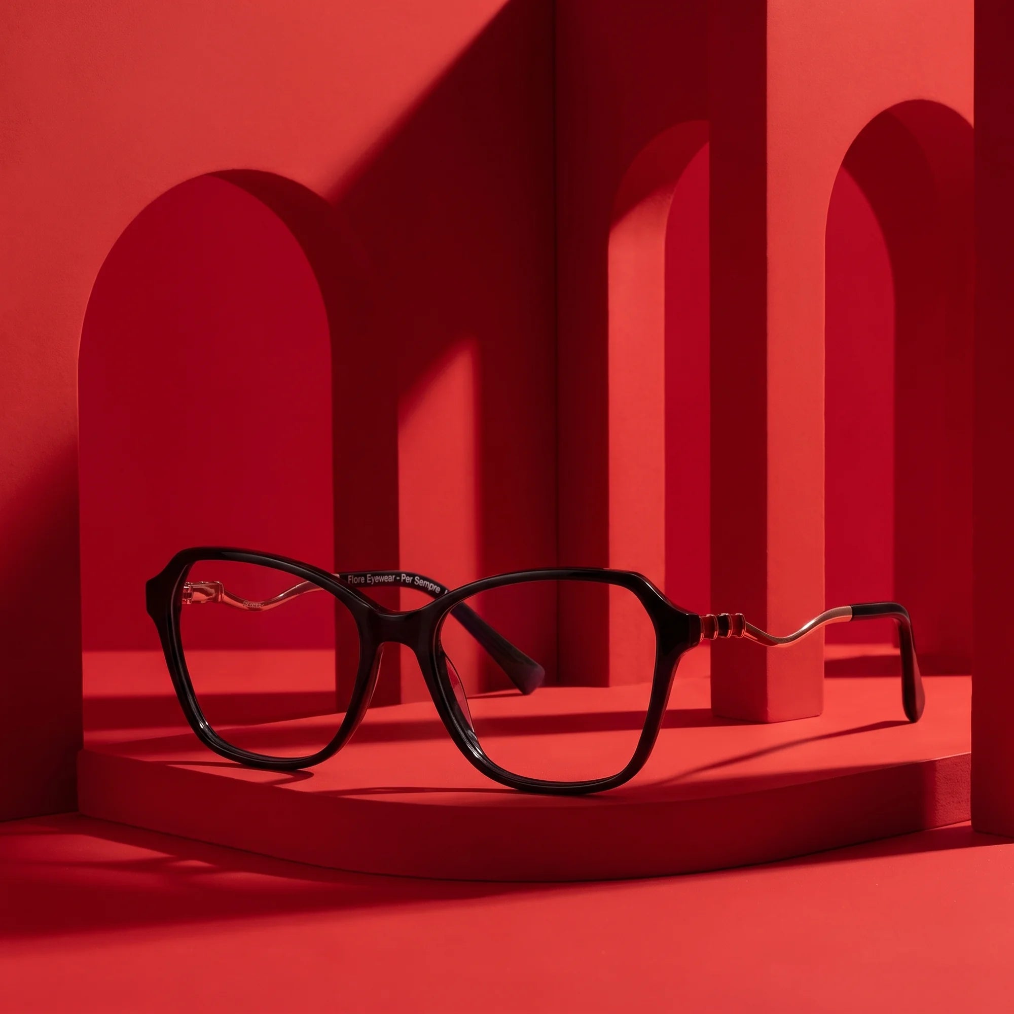 Fiore 1030 eyeglasses in black – staged on a sculptural vivid red architecture set