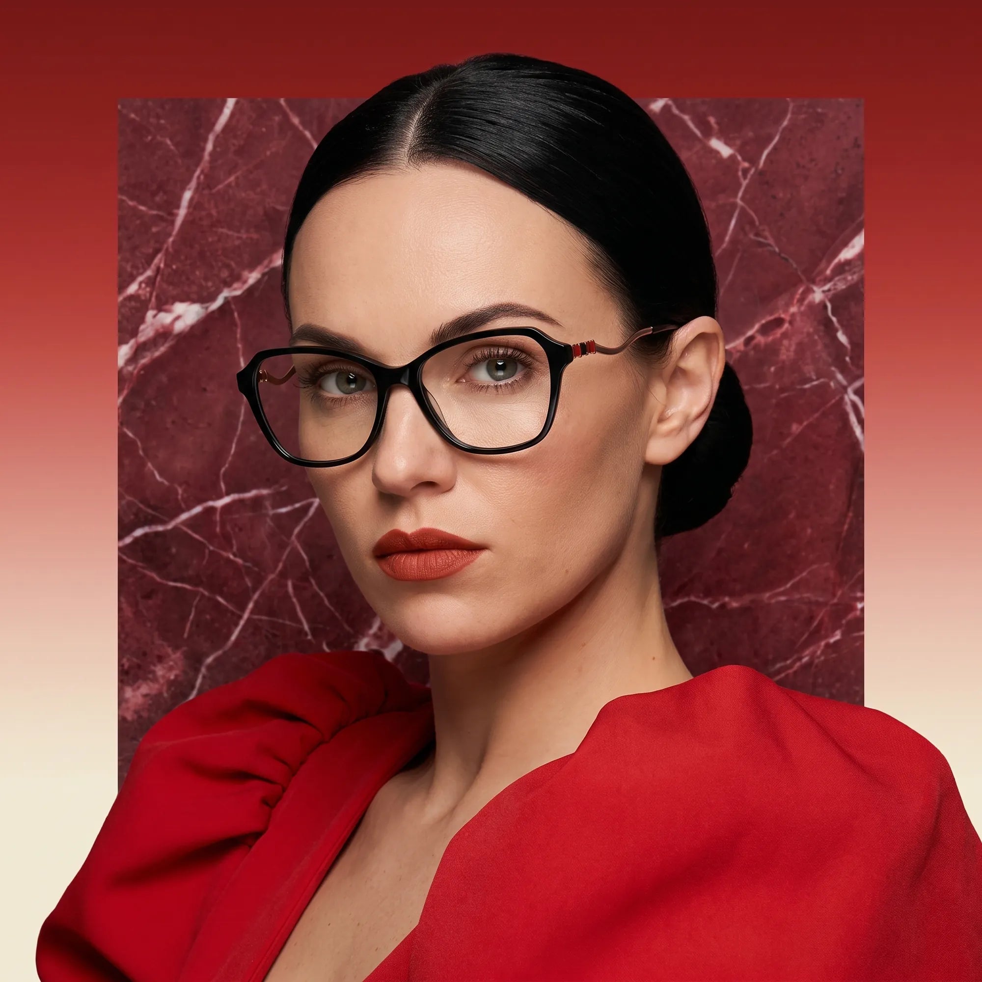 Fiore 1030 eyeglasses in black, worn by a model – campaign portrait, red marble backdrop and draped scarlet dress