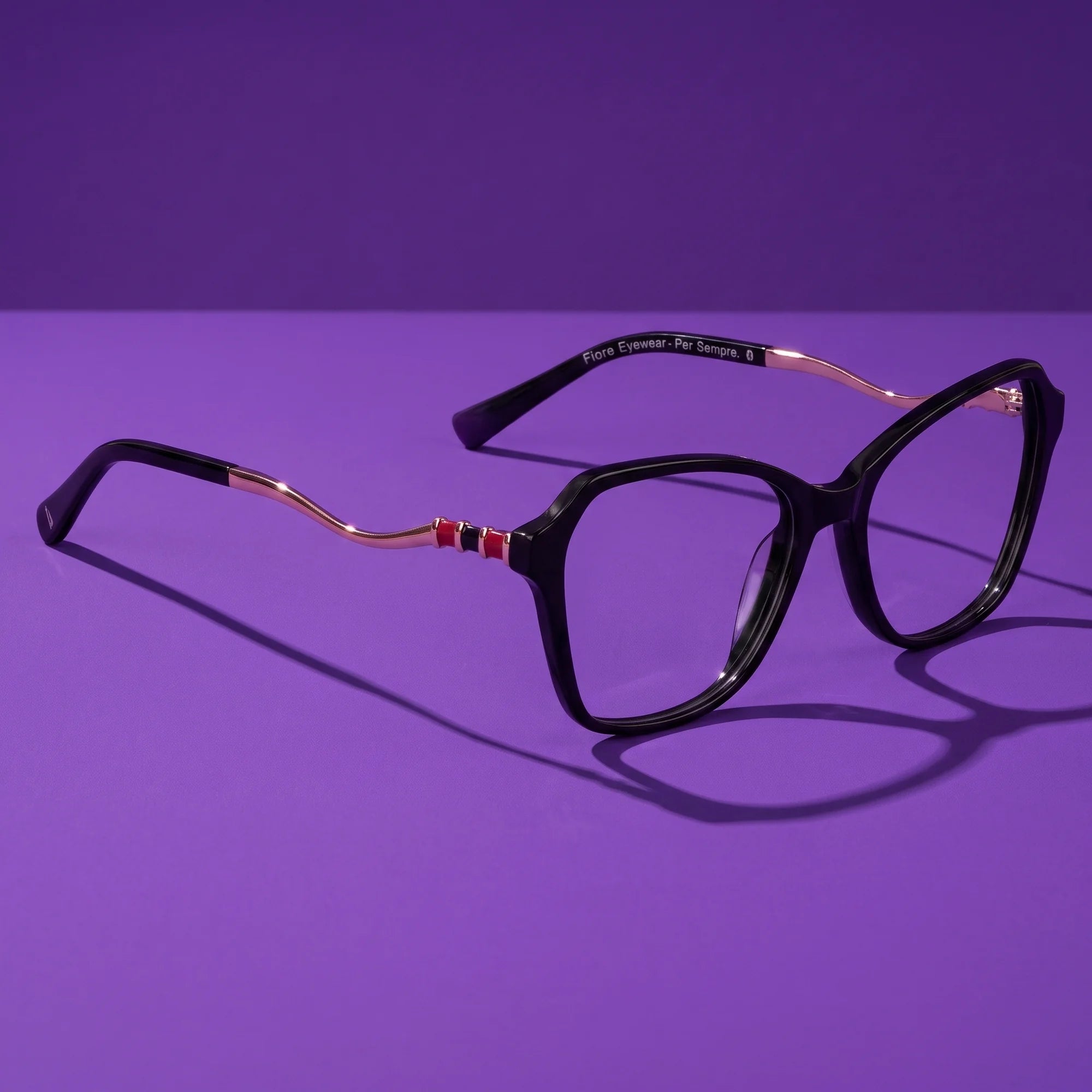 Fiore 1030 eyeglasses in black – hero still life against a deep violet backdrop