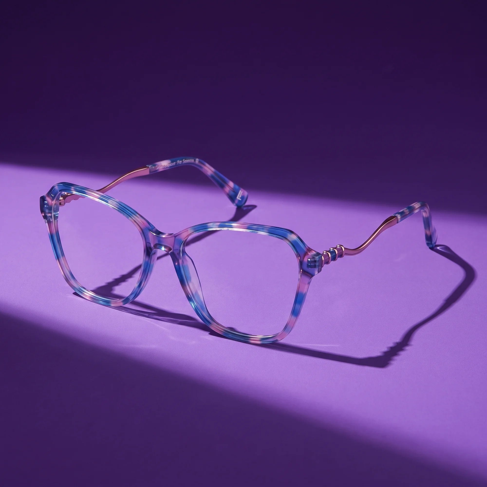 Fiore 1030 eyeglasses in blue pink – still life on a seamless violet studio backdrop