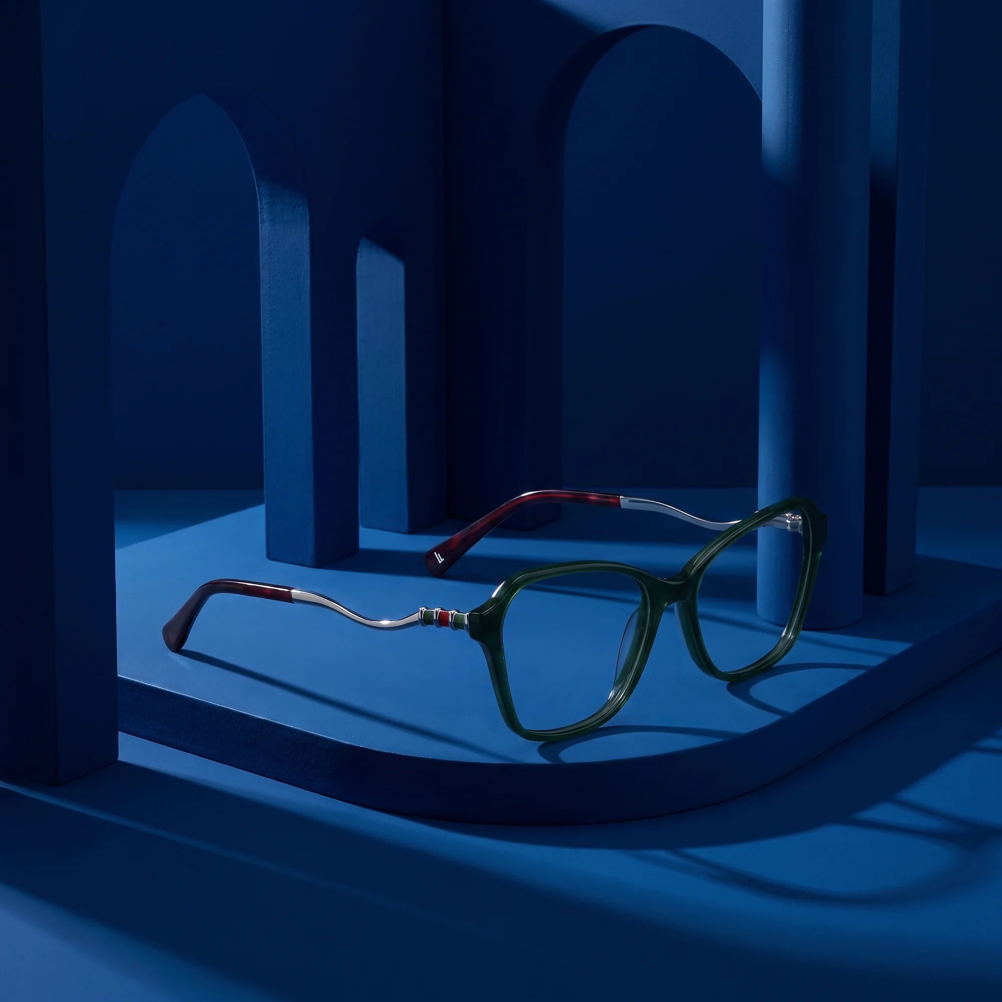 Fiore 1030 eyeglasses in green – still life among monochrome midnight blue arches