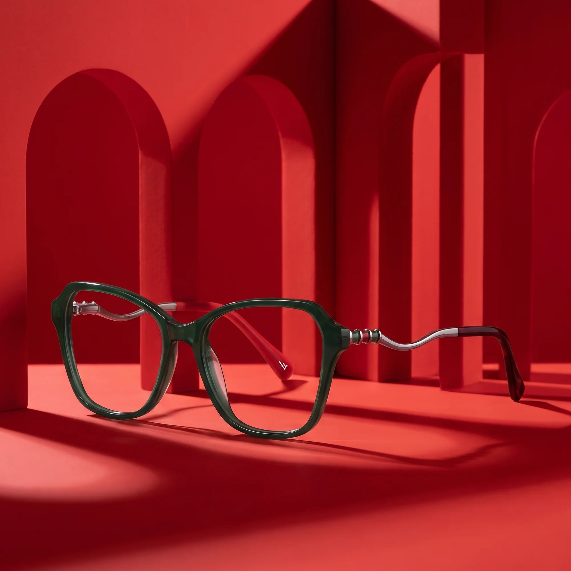 Fiore 1030 eyeglasses in green – staged on a sculptural vivid red architecture set