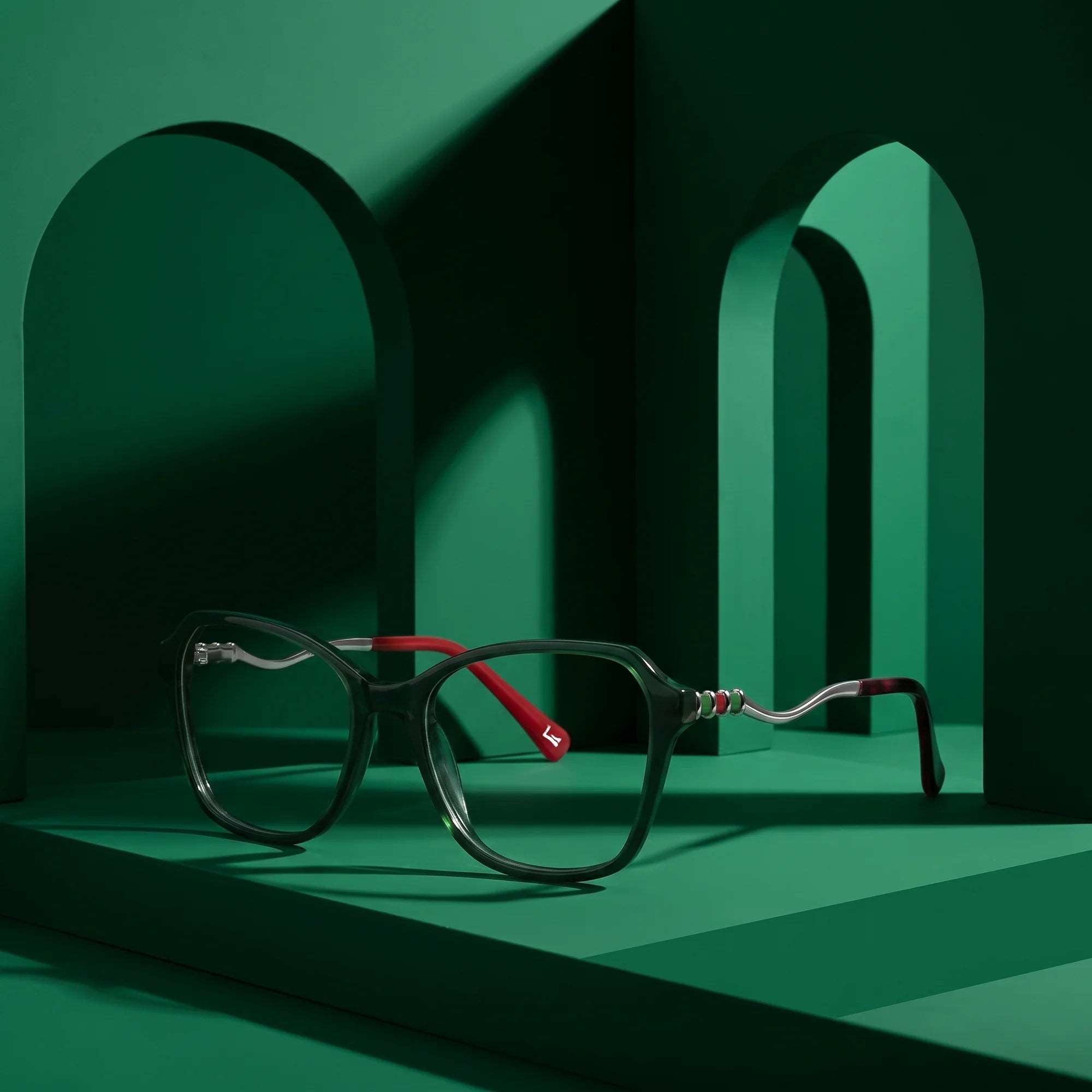 Fiore 1030 eyeglasses in green – displayed on a emerald podium among arches