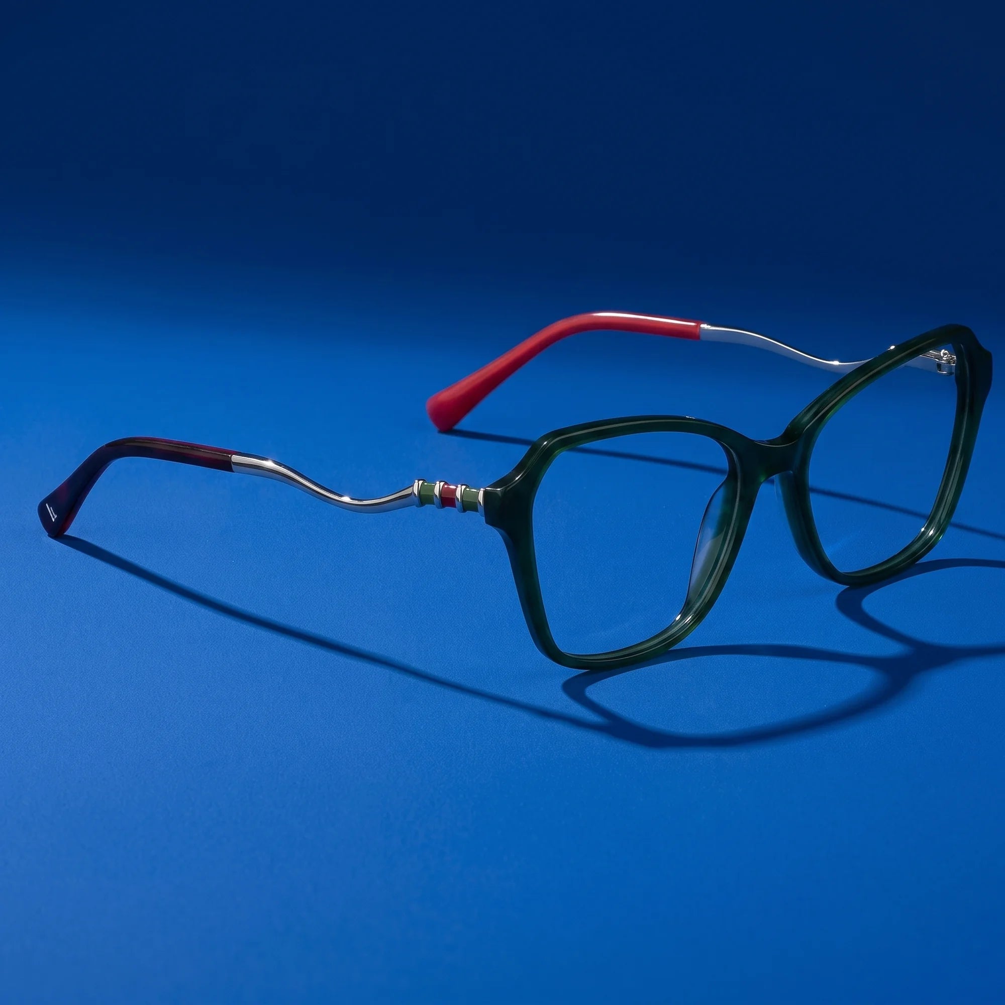 Fiore 1030 eyeglasses in green – editorial still life on a saturated cobalt set