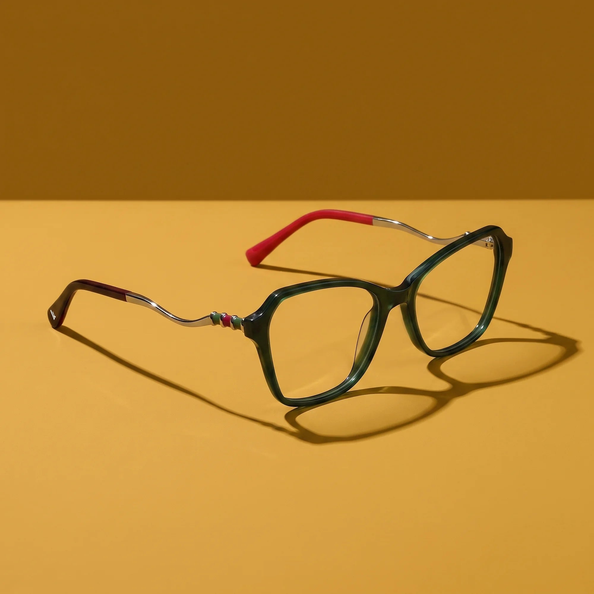 Fiore 1030 eyeglasses in green – still life on a seamless mustard ochre studio backdrop