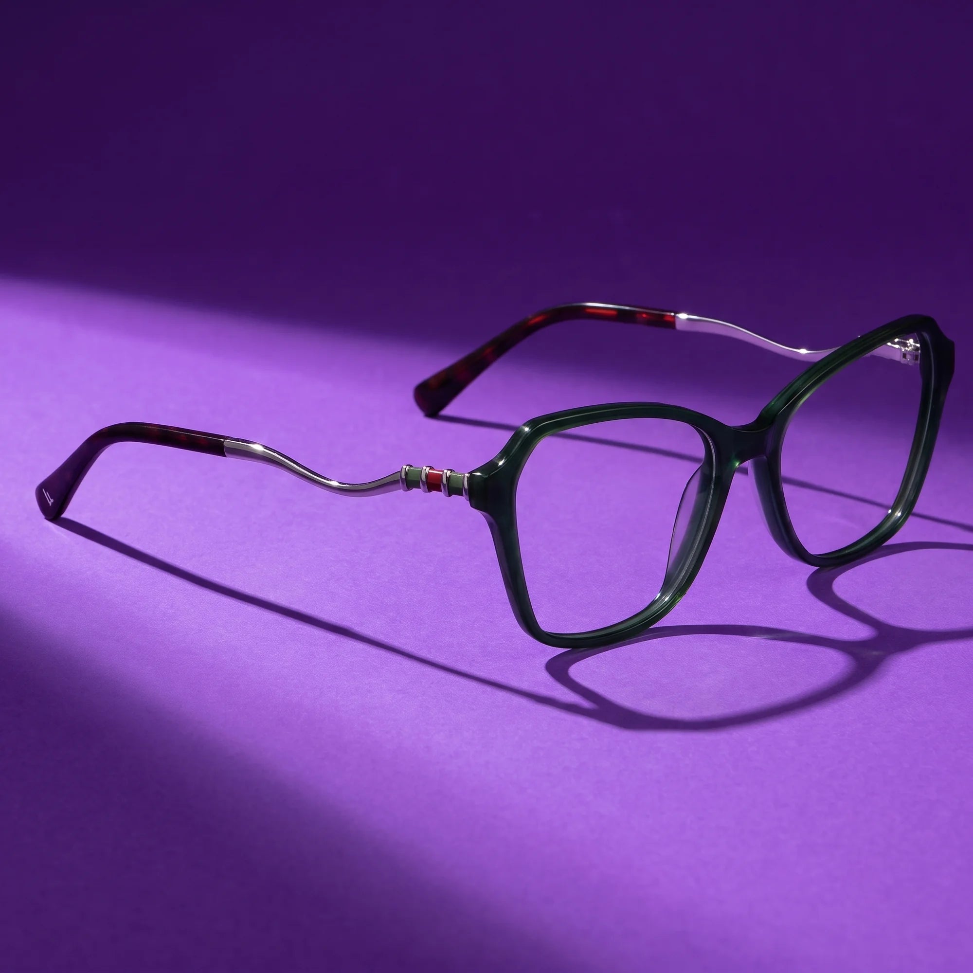 Fiore 1030 eyeglasses in green – hero still life against a deep violet backdrop