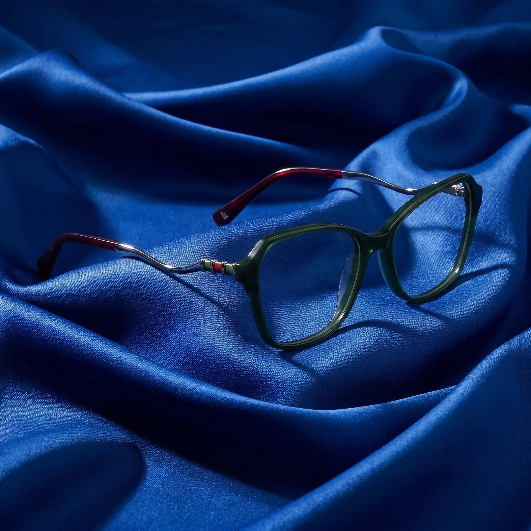 Fiore 1030 eyeglasses in green – nested in flowing cobalt silk
