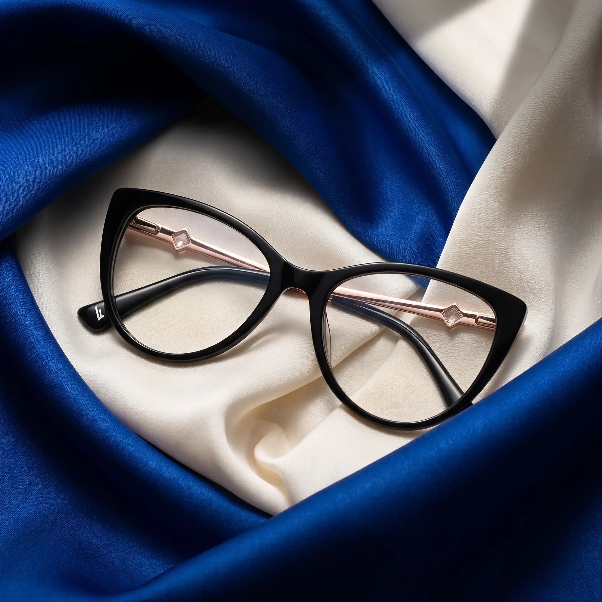 Fiore 1031 eyeglasses in black – resting on draped cobalt and ivory silk