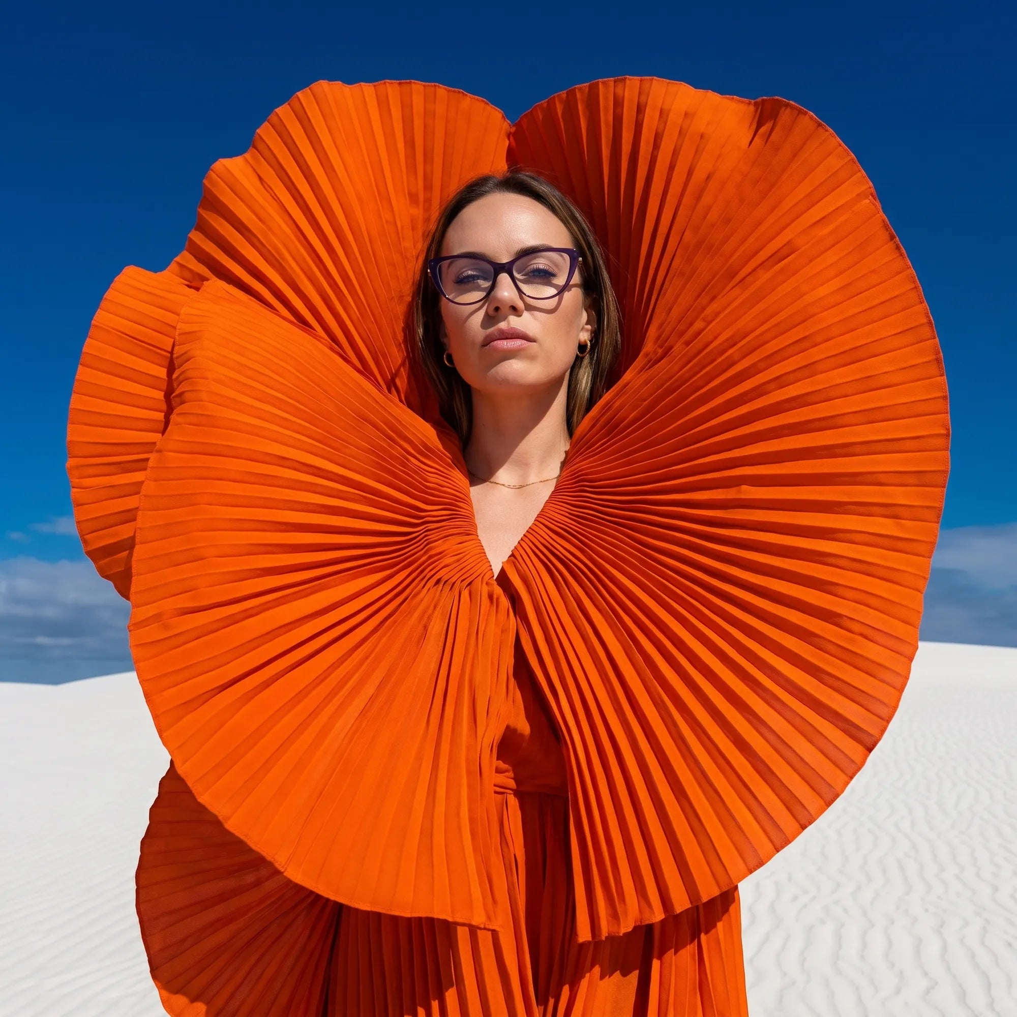 Fiore 1031 eyeglasses in purple green, worn by a model – campaign portrait, sculptural orange pleated fan on white dunes