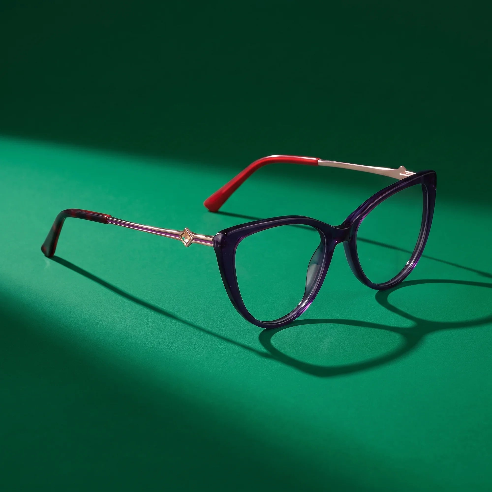 Fiore 1031 eyeglasses in purple green – editorial still life on a saturated emerald set