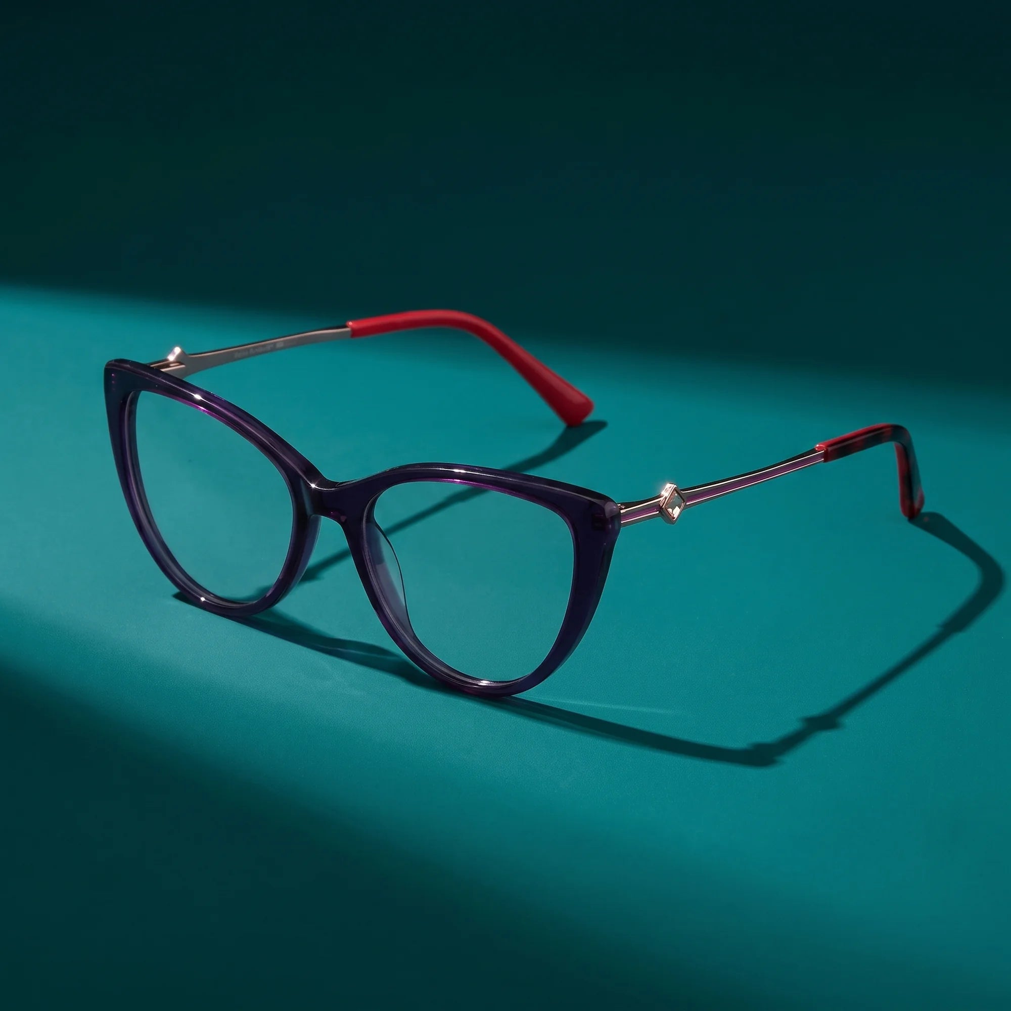 Fiore 1031 eyeglasses in purple green – hero still life against a deep teal backdrop