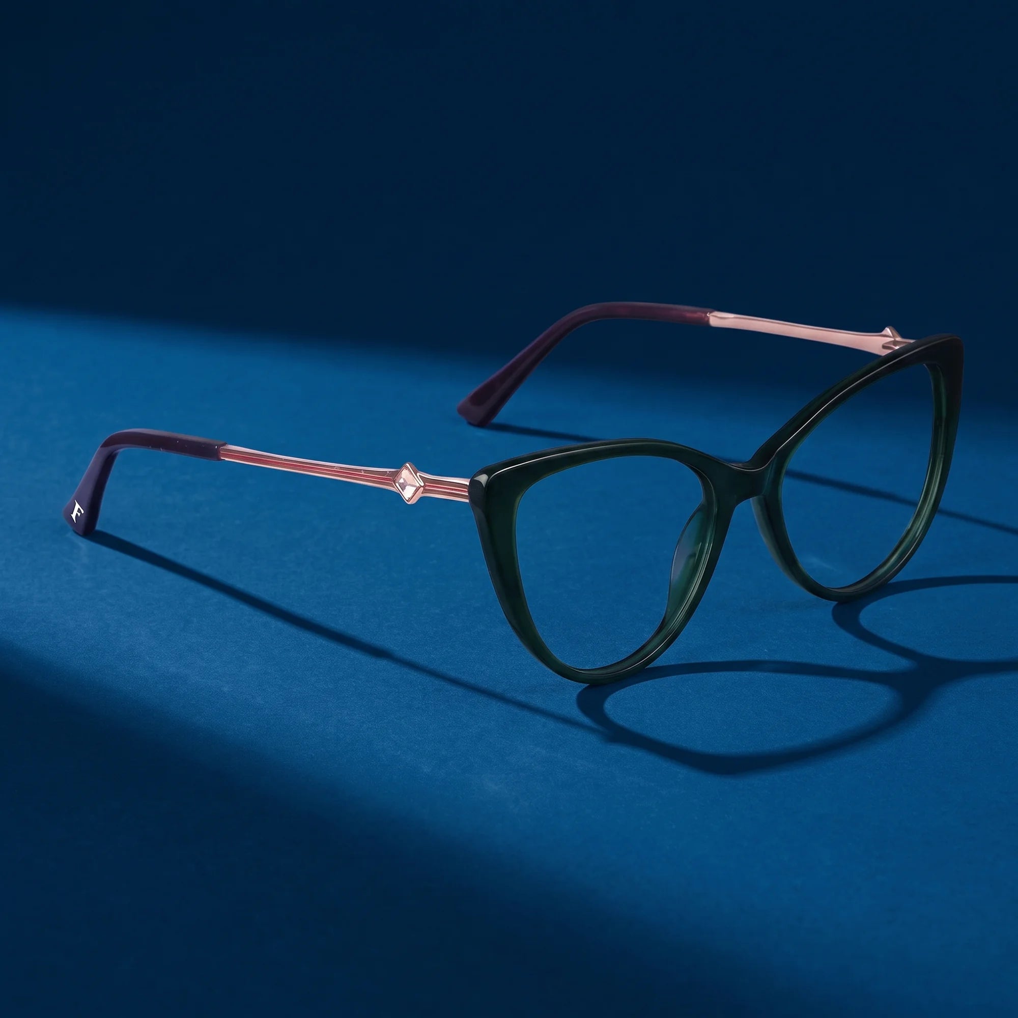 Fiore 1031 eyeglasses in green – editorial still life on a saturated midnight blue set