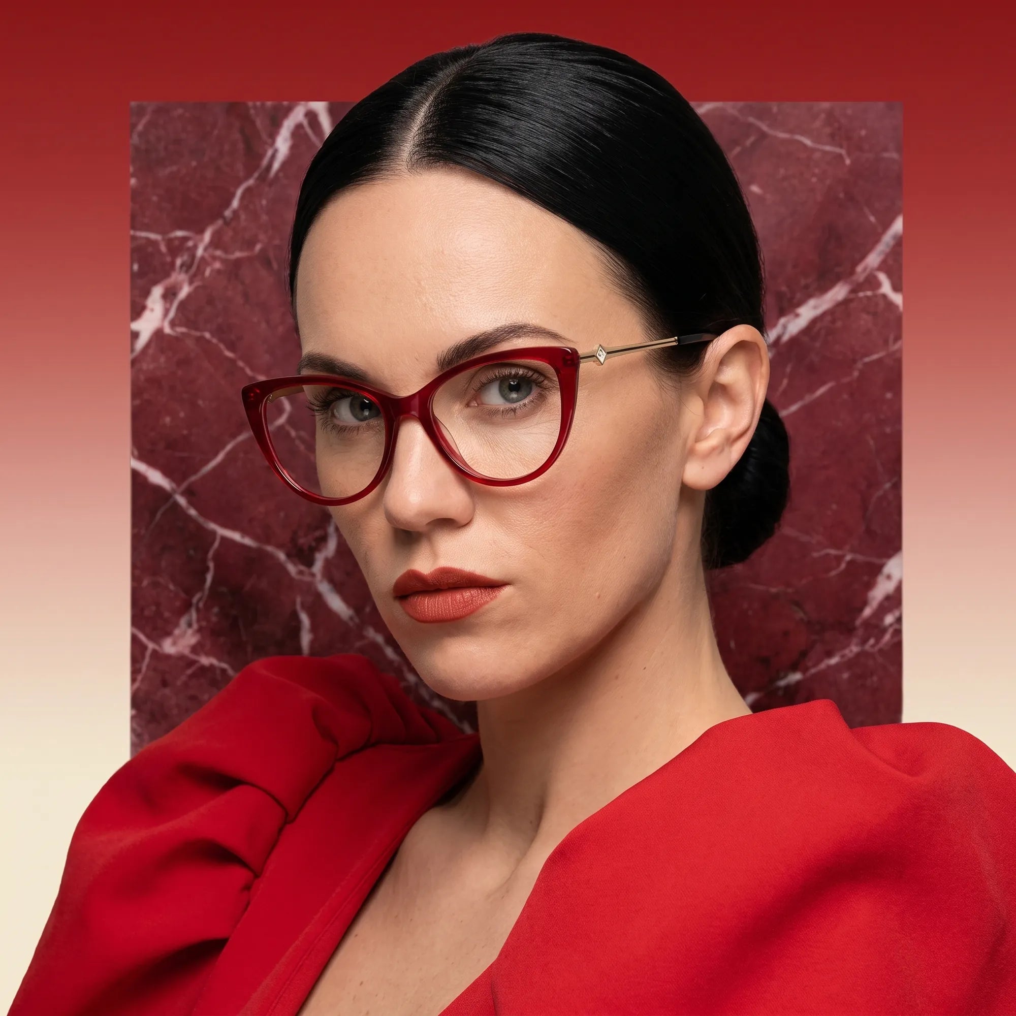 Fiore 1031 eyeglasses in red, worn by a model – campaign portrait, red marble backdrop and draped scarlet dress