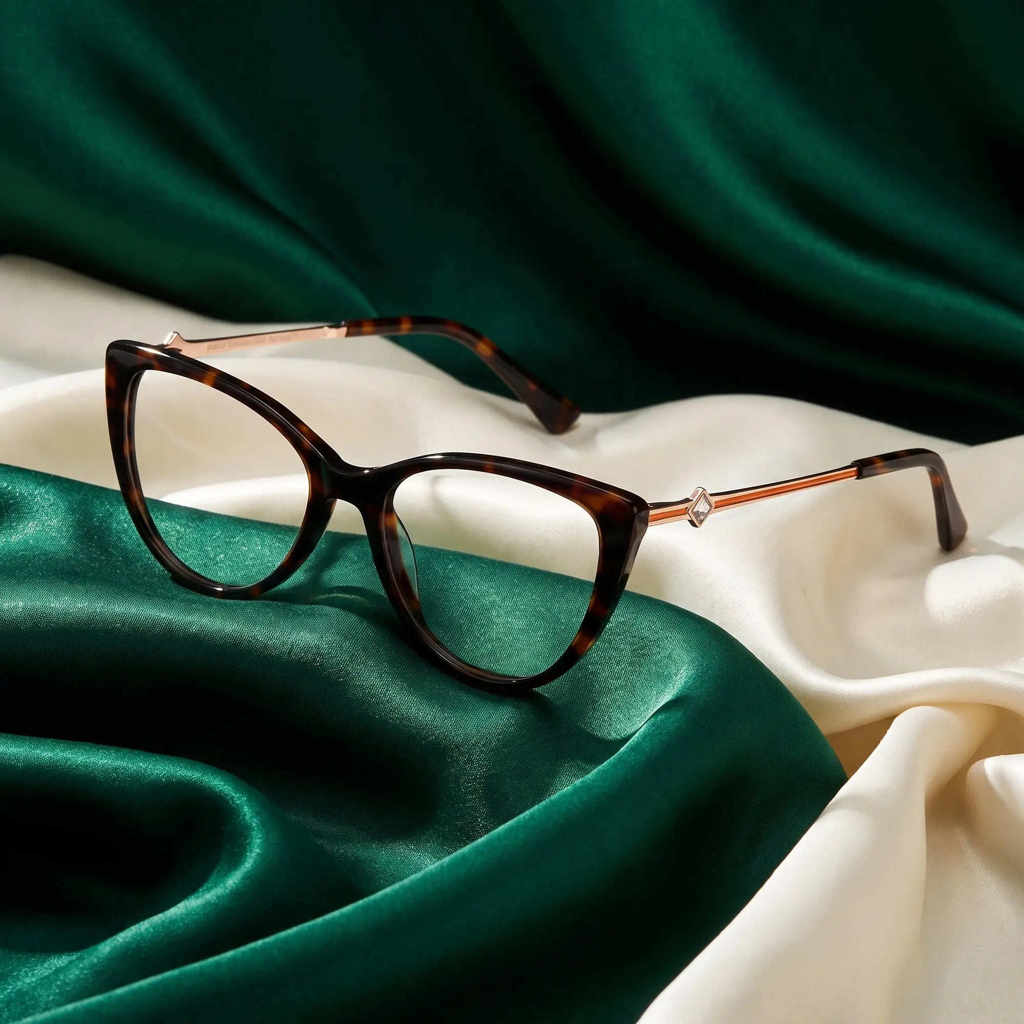 Fiore 1031 eyeglasses in tortoiseshell – resting on draped emerald and ivory silk