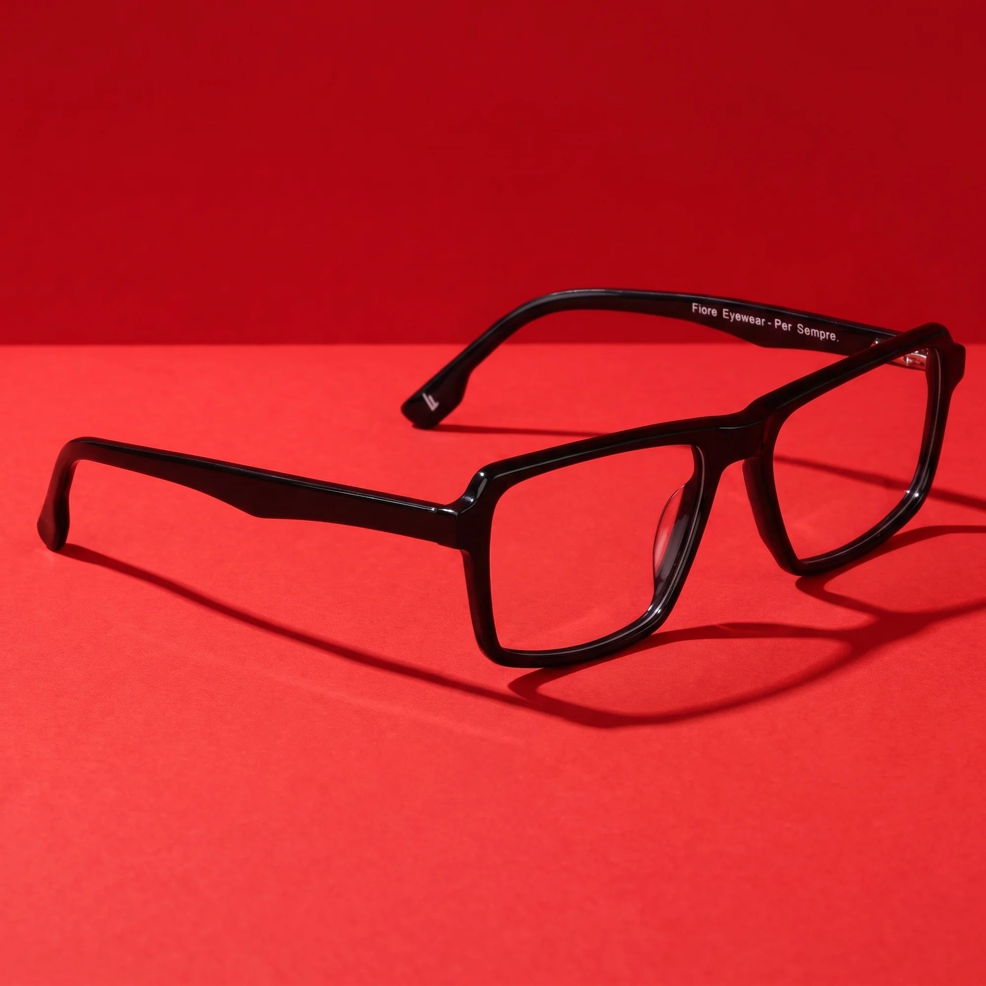 Fiore 1038 eyeglasses in black – editorial still life on a saturated vivid red set
