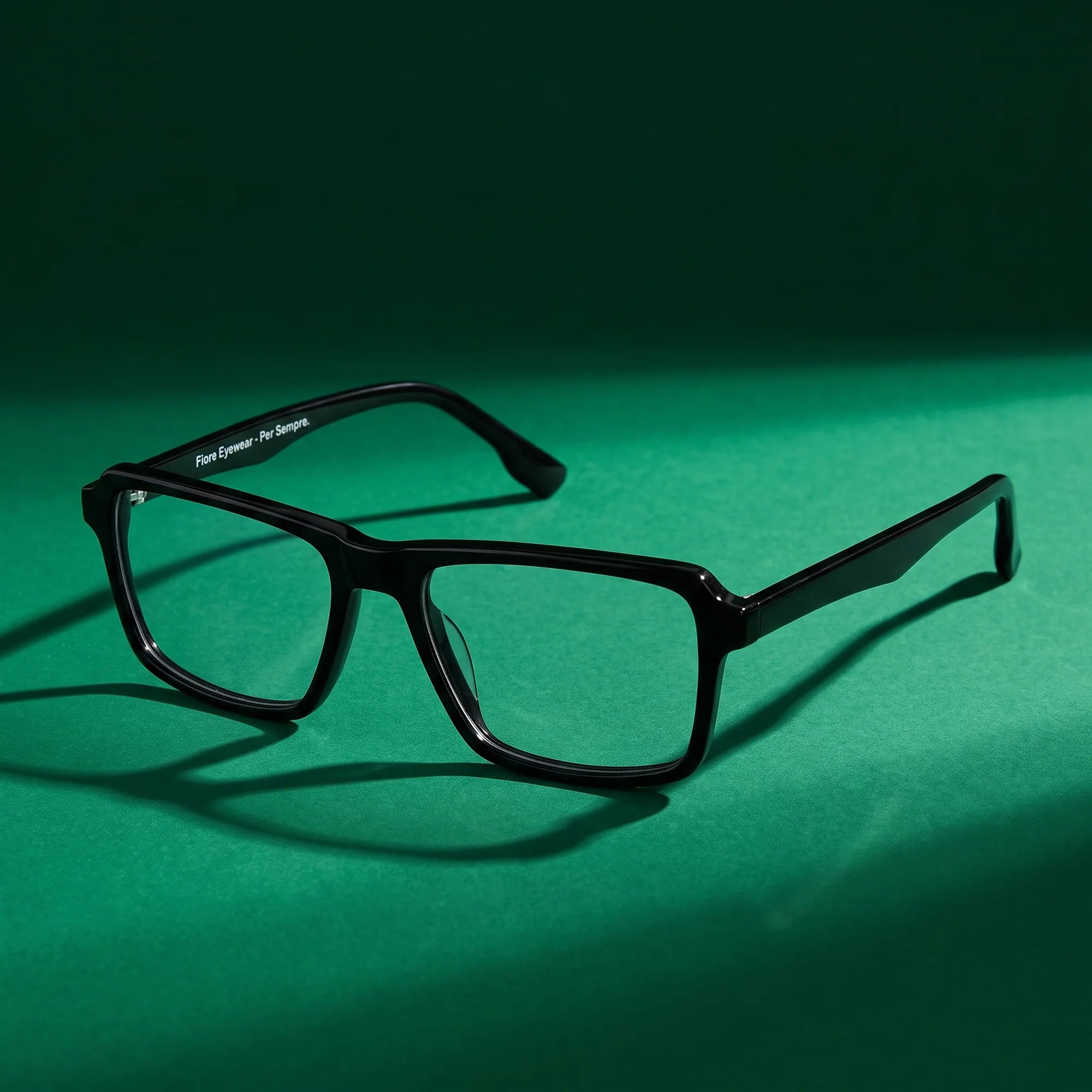 Fiore 1038 eyeglasses in black – still life on a seamless emerald studio backdrop