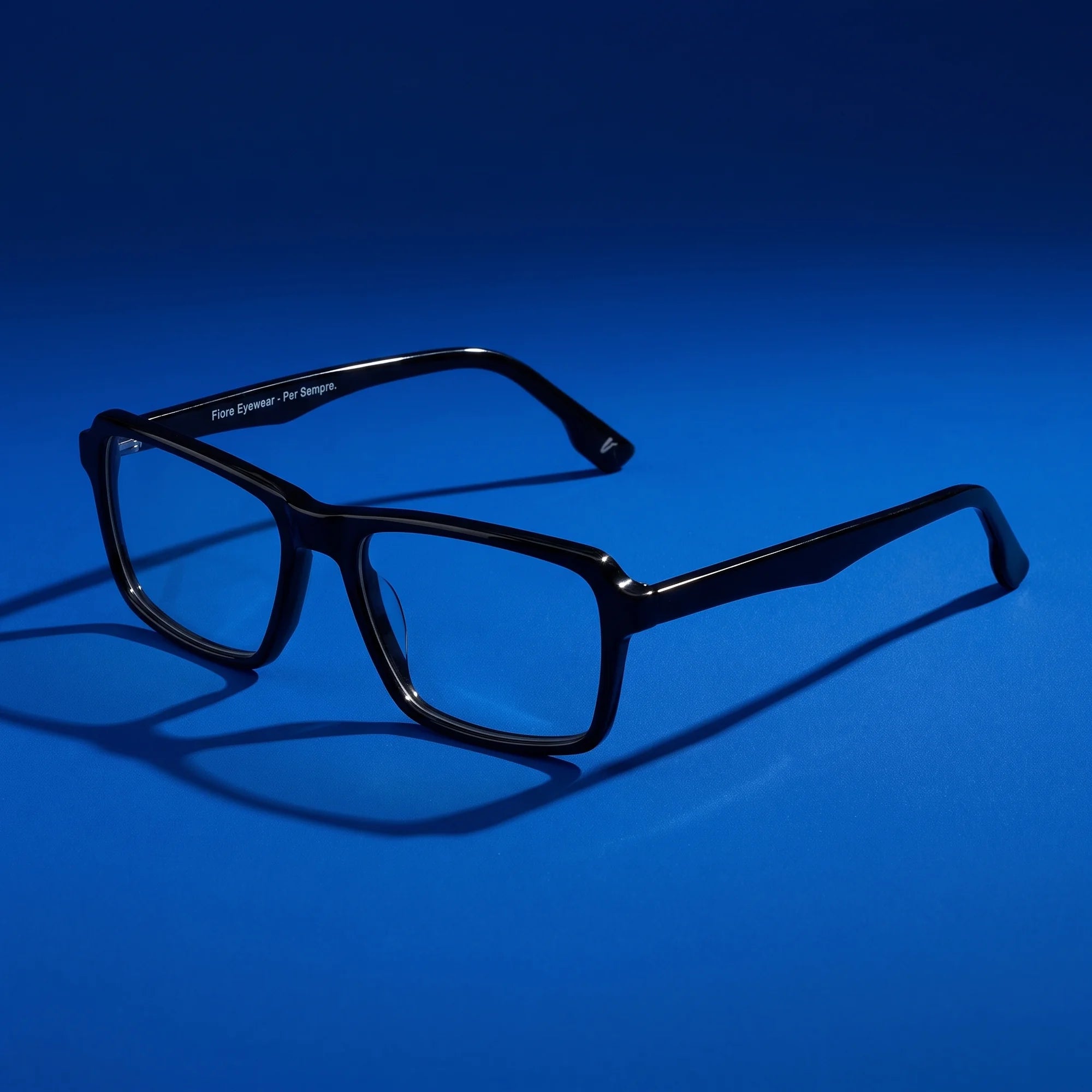 Fiore 1038 eyeglasses in black – hero still life against a deep cobalt backdrop