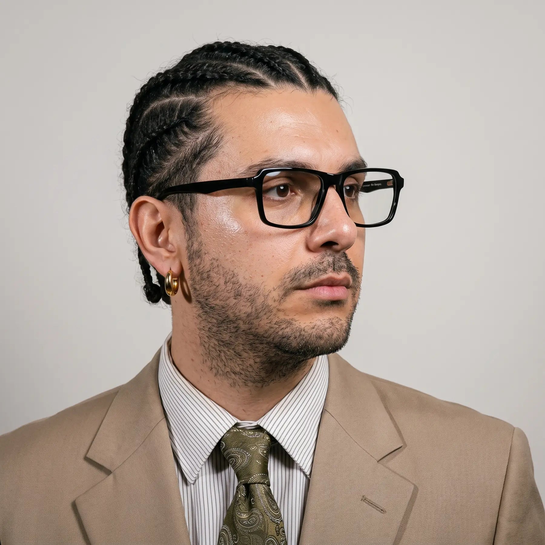 Fiore 1038 eyeglasses in black, worn by a model – campaign portrait, clean beige studio three-quarter portrait