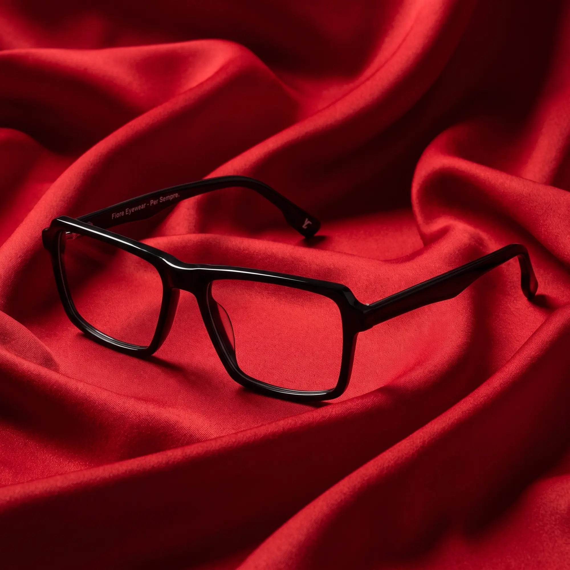Fiore 1038 eyeglasses in black – nested in flowing vivid red silk