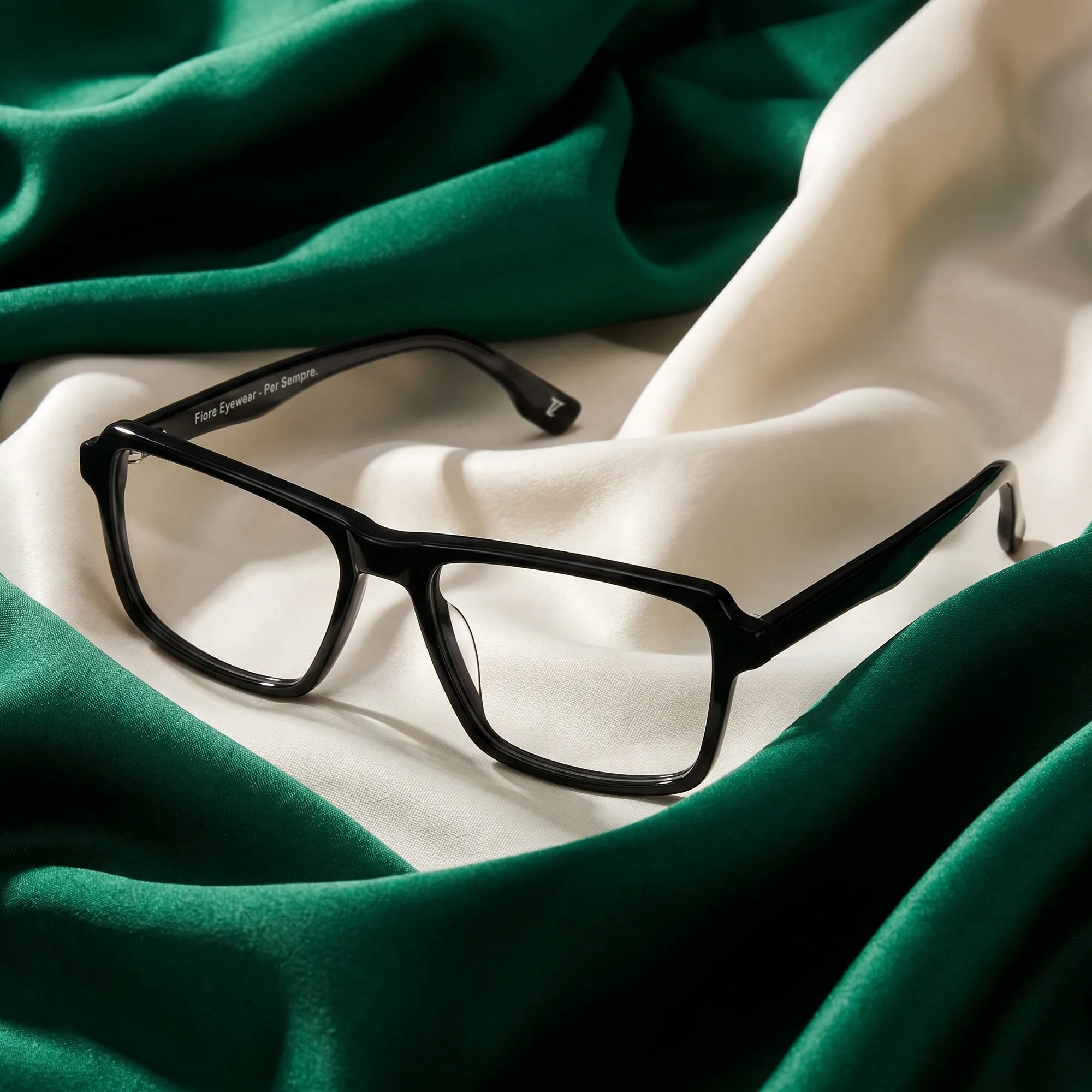 Fiore 1038 eyeglasses in black – resting on draped emerald and ivory silk