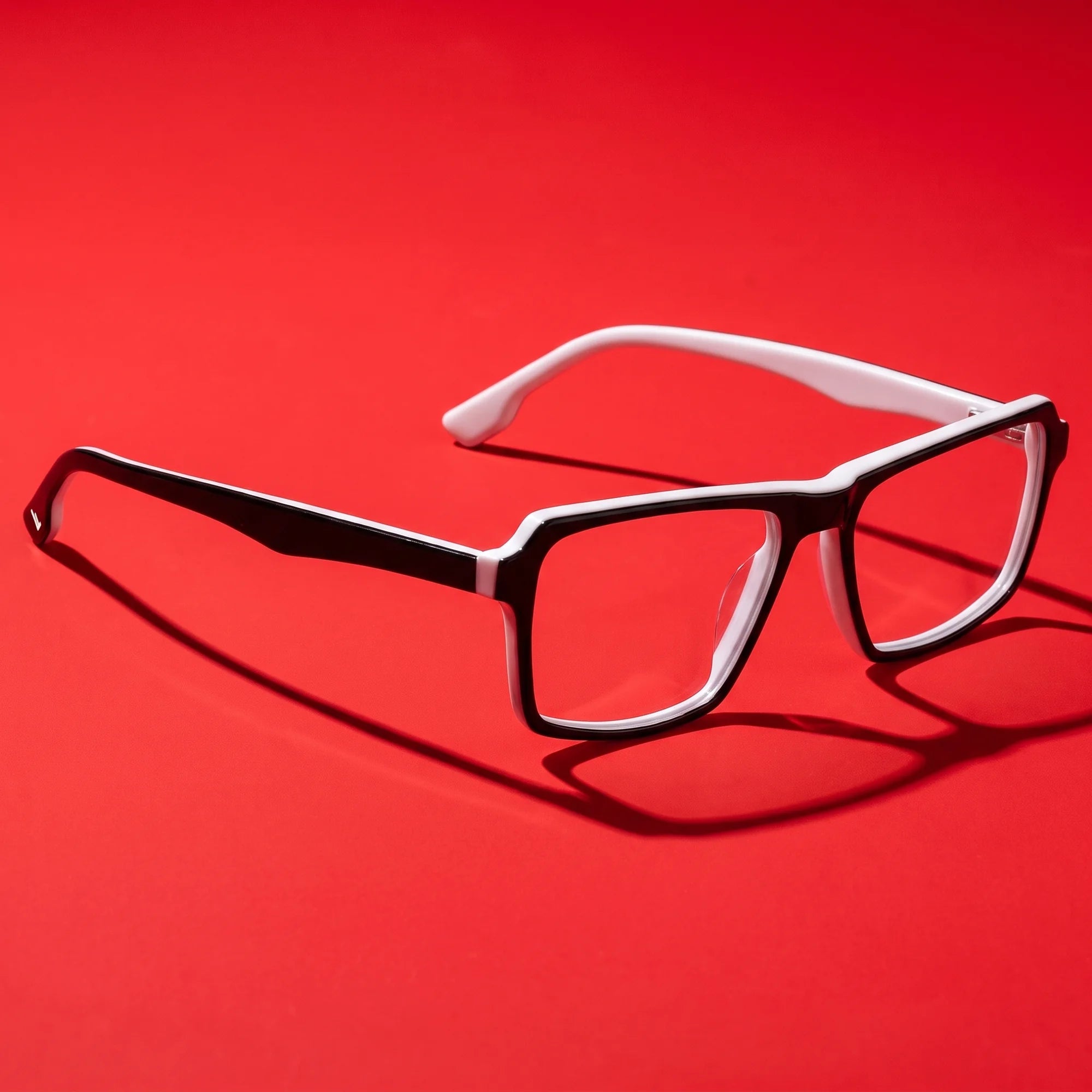 Fiore 1038 eyeglasses in black white – editorial still life on a saturated vivid red set