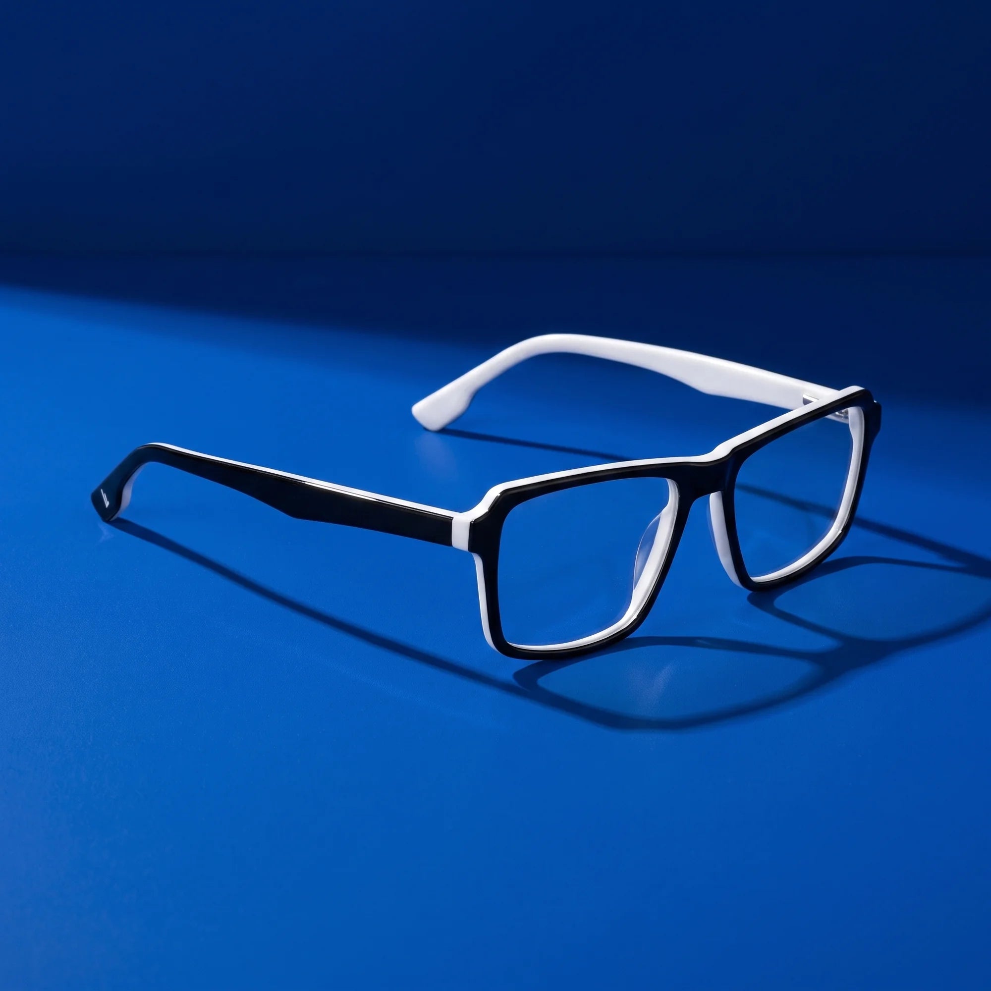 Fiore 1038 eyeglasses in black white – hero still life against a deep cobalt backdrop