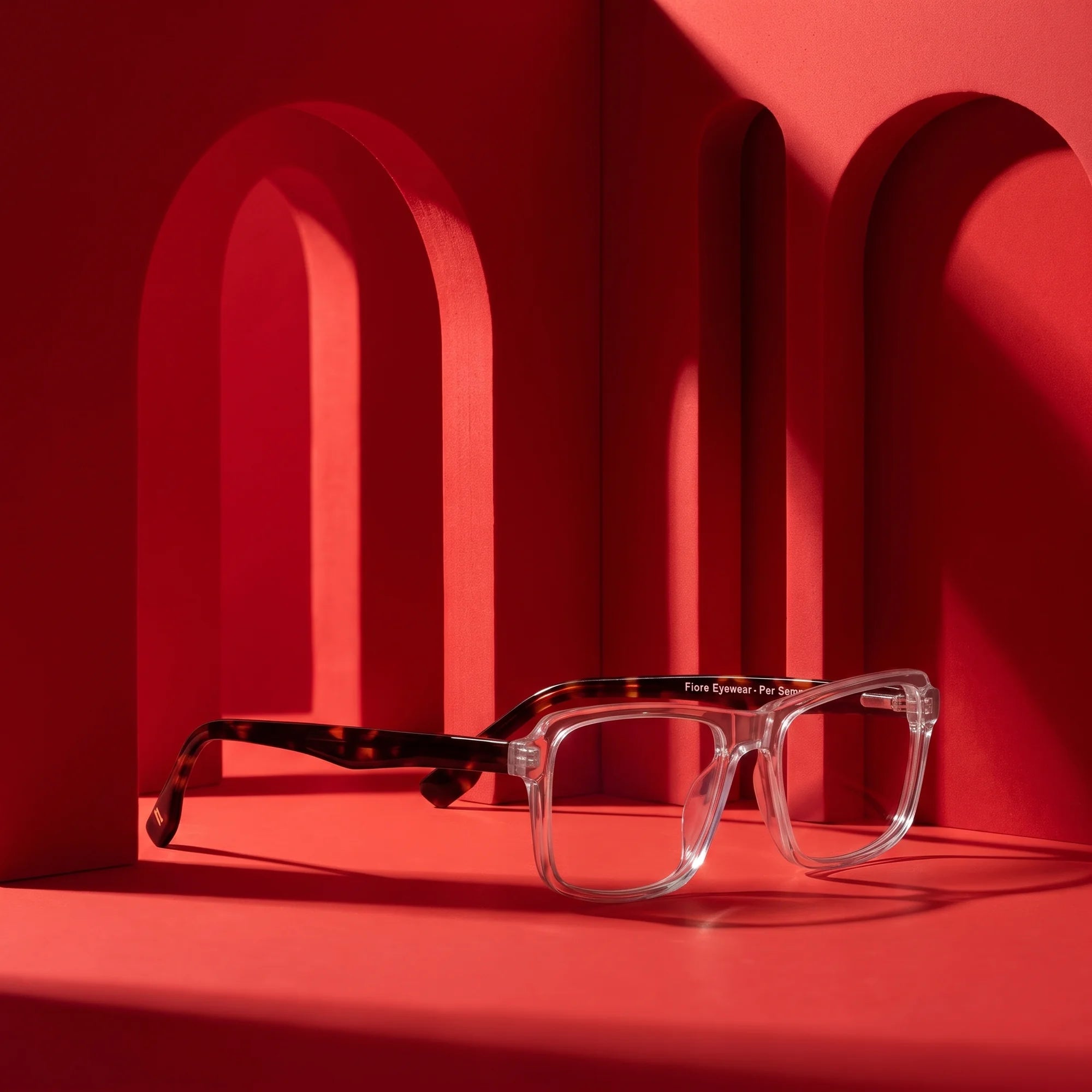 Fiore 1038 eyeglasses in transparent – staged on a sculptural vivid red architecture set