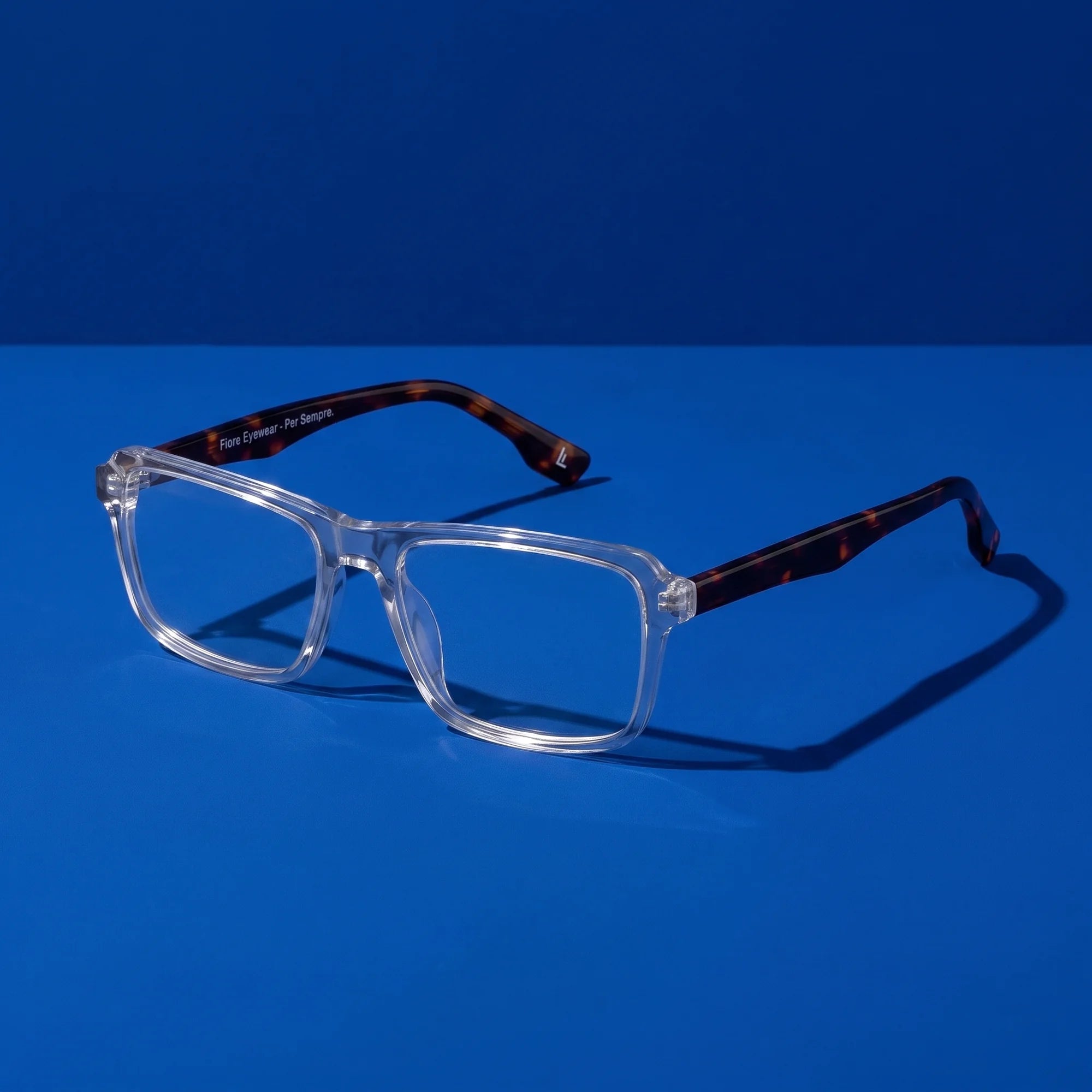 Fiore 1038 eyeglasses in transparent – still life on a seamless cobalt studio backdrop