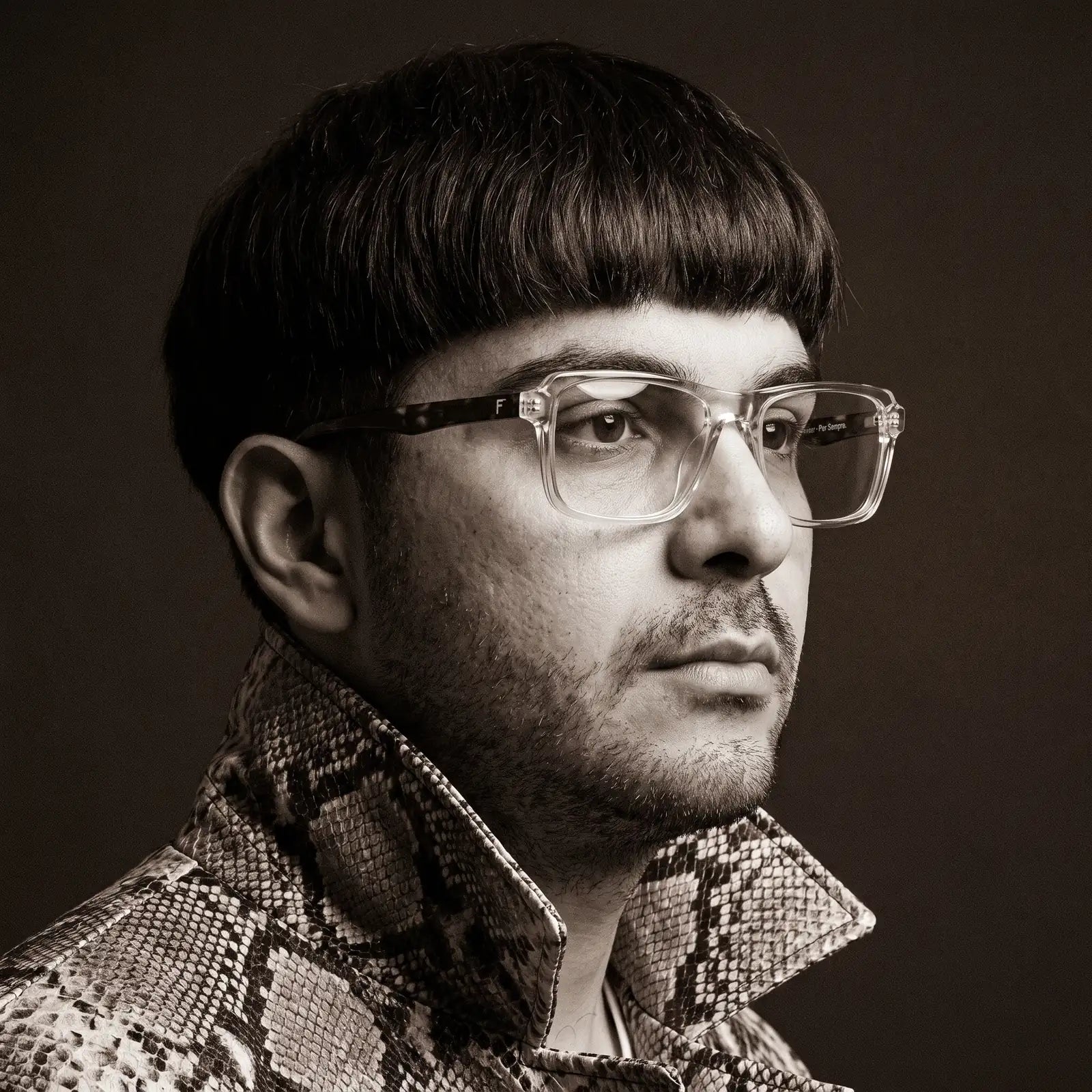 Fiore 1038 eyeglasses in transparent, worn by a model – campaign portrait, monochrome studio portrait, red graphic accents
