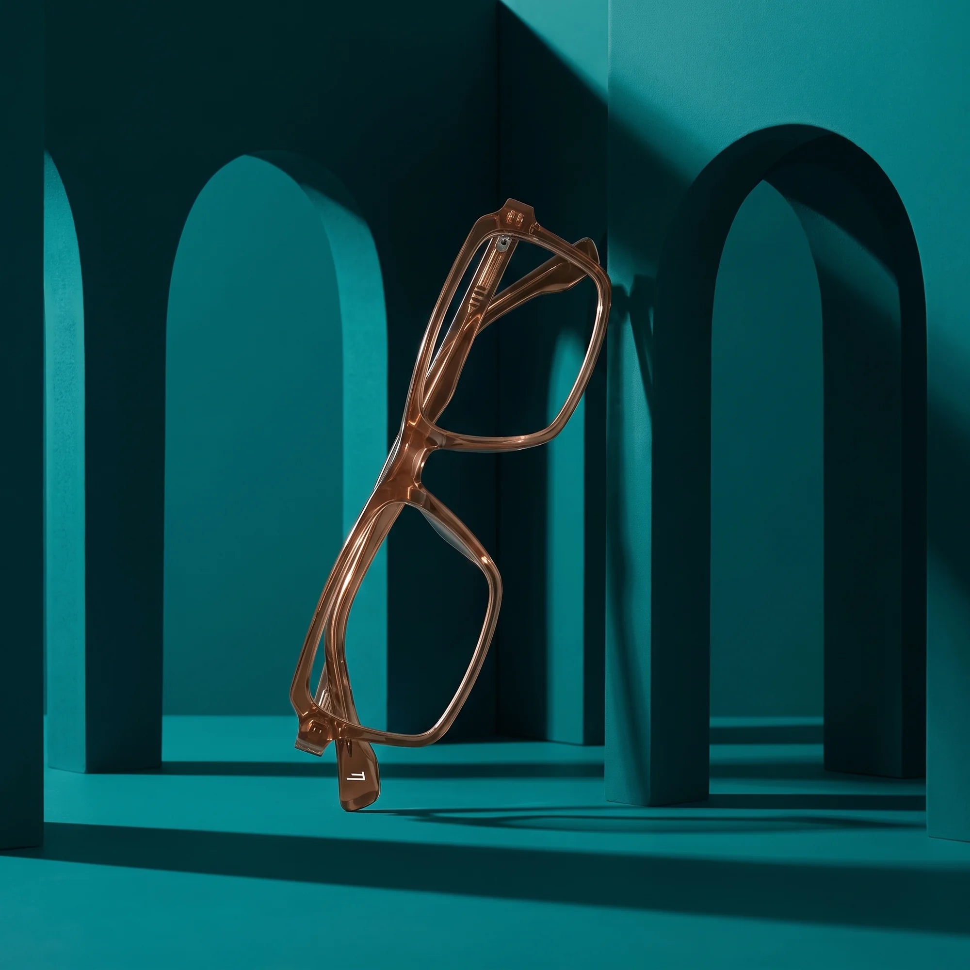 Fiore 1038 eyeglasses in brown – staged on a sculptural teal architecture set