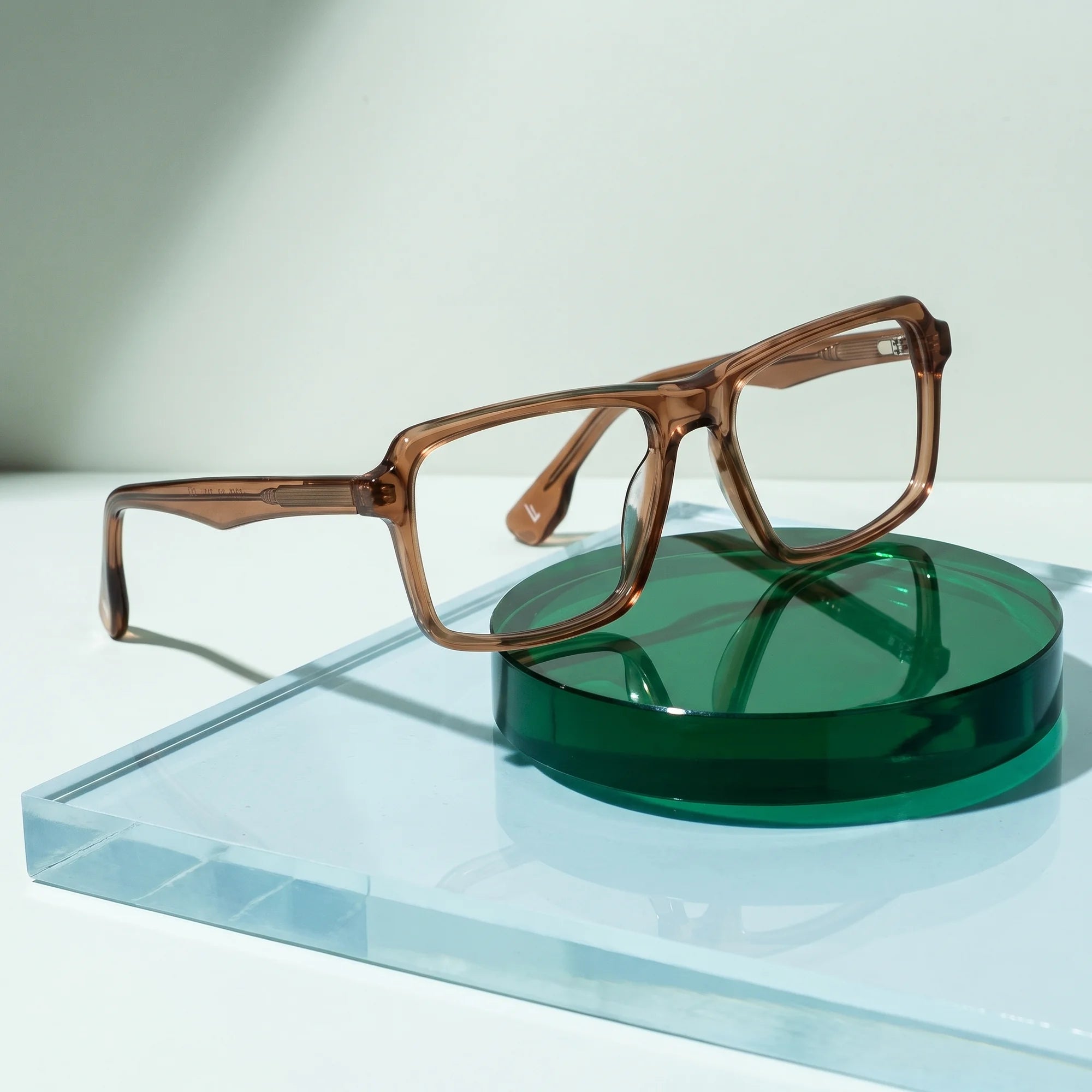 Fiore 1038 eyeglasses in brown – on a cobalt acrylic disc in soft daylight