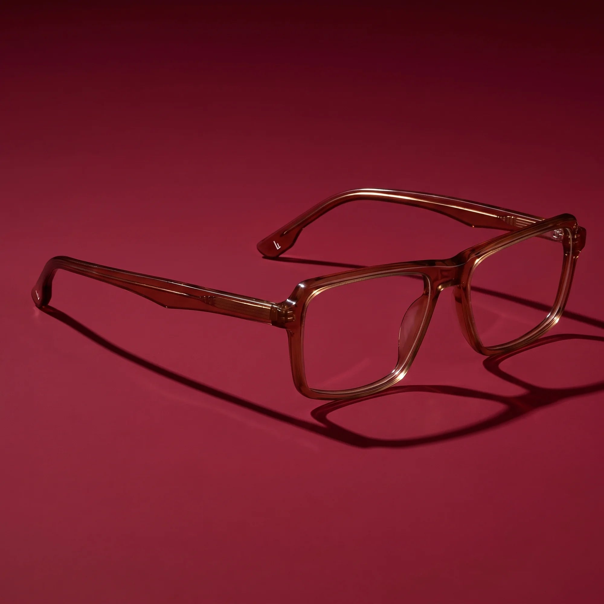 Fiore 1038 eyeglasses in brown – editorial still life on a saturated burgundy set