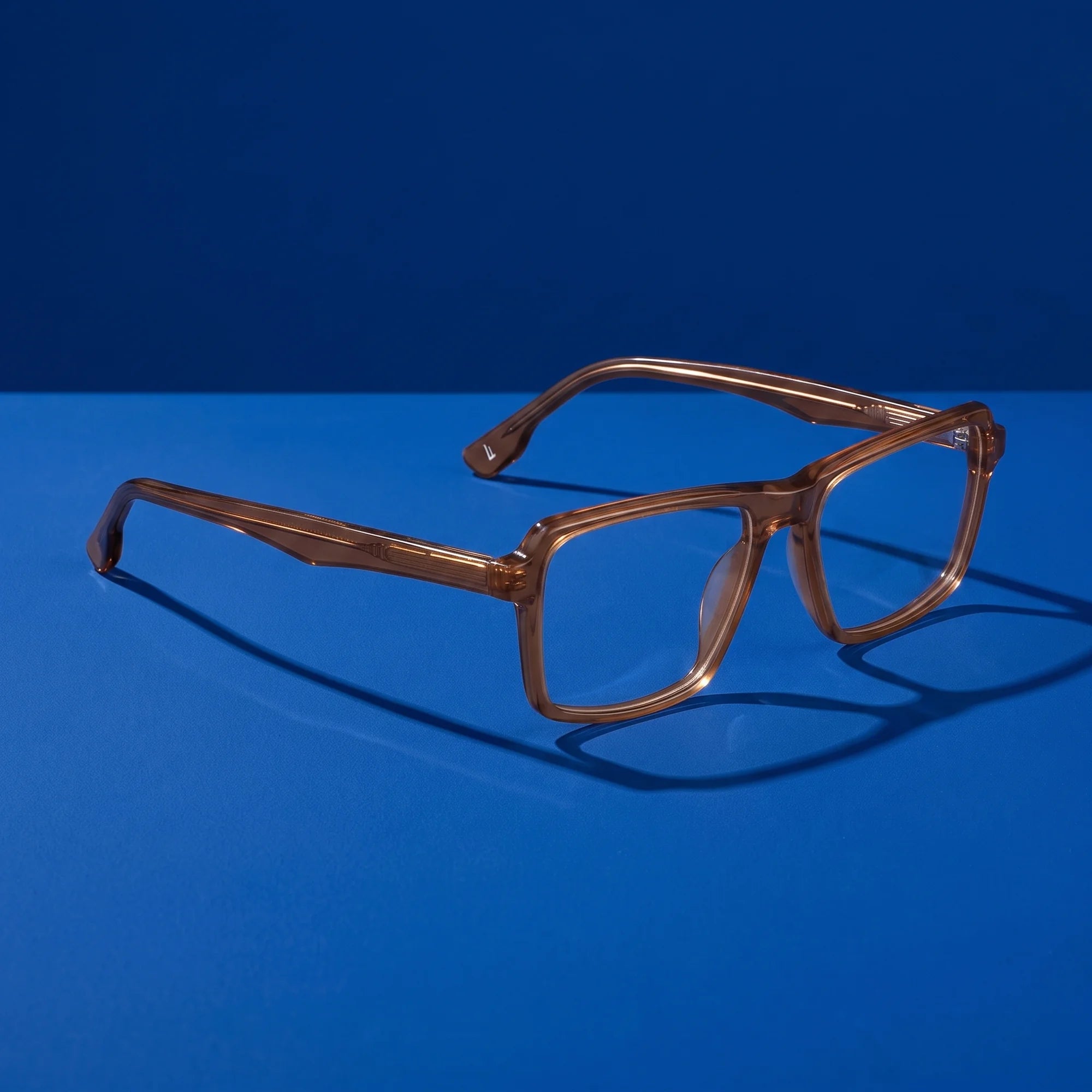 Fiore 1038 eyeglasses in brown – hero still life against a deep cobalt backdrop