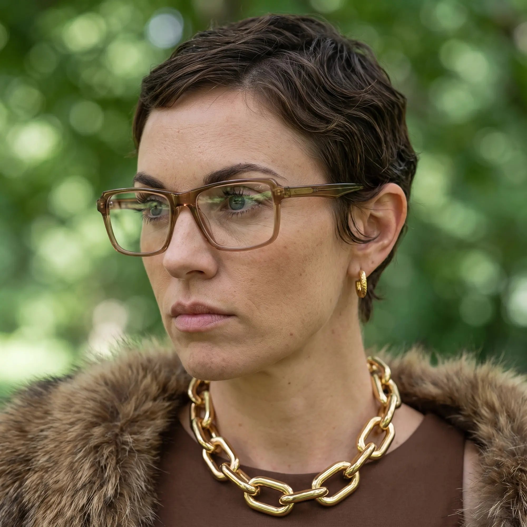 Fiore 1038 eyeglasses in brown, worn by a model – campaign portrait, fur-collar portrait in dappled daylight