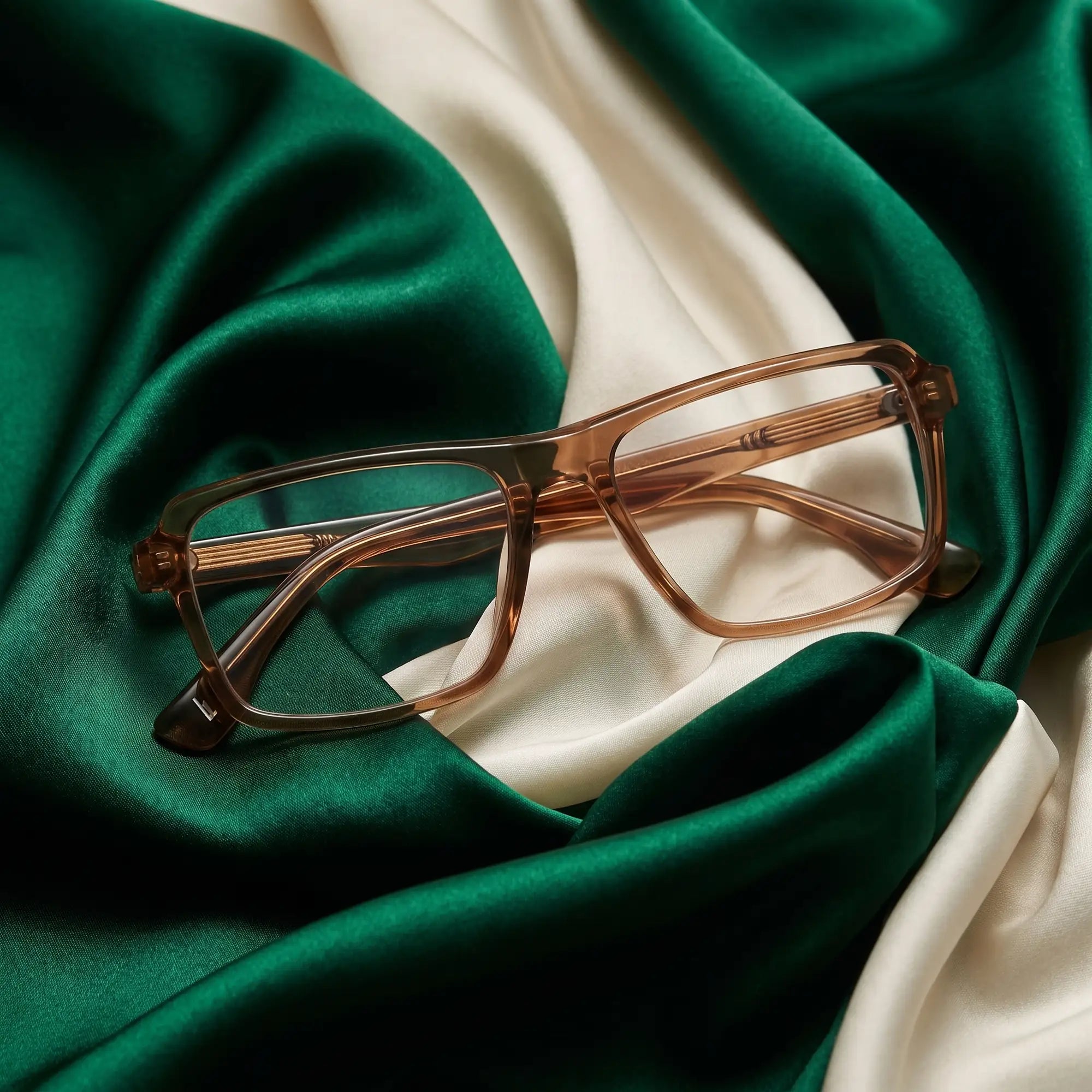 Fiore 1038 eyeglasses in brown – resting on draped emerald and ivory silk