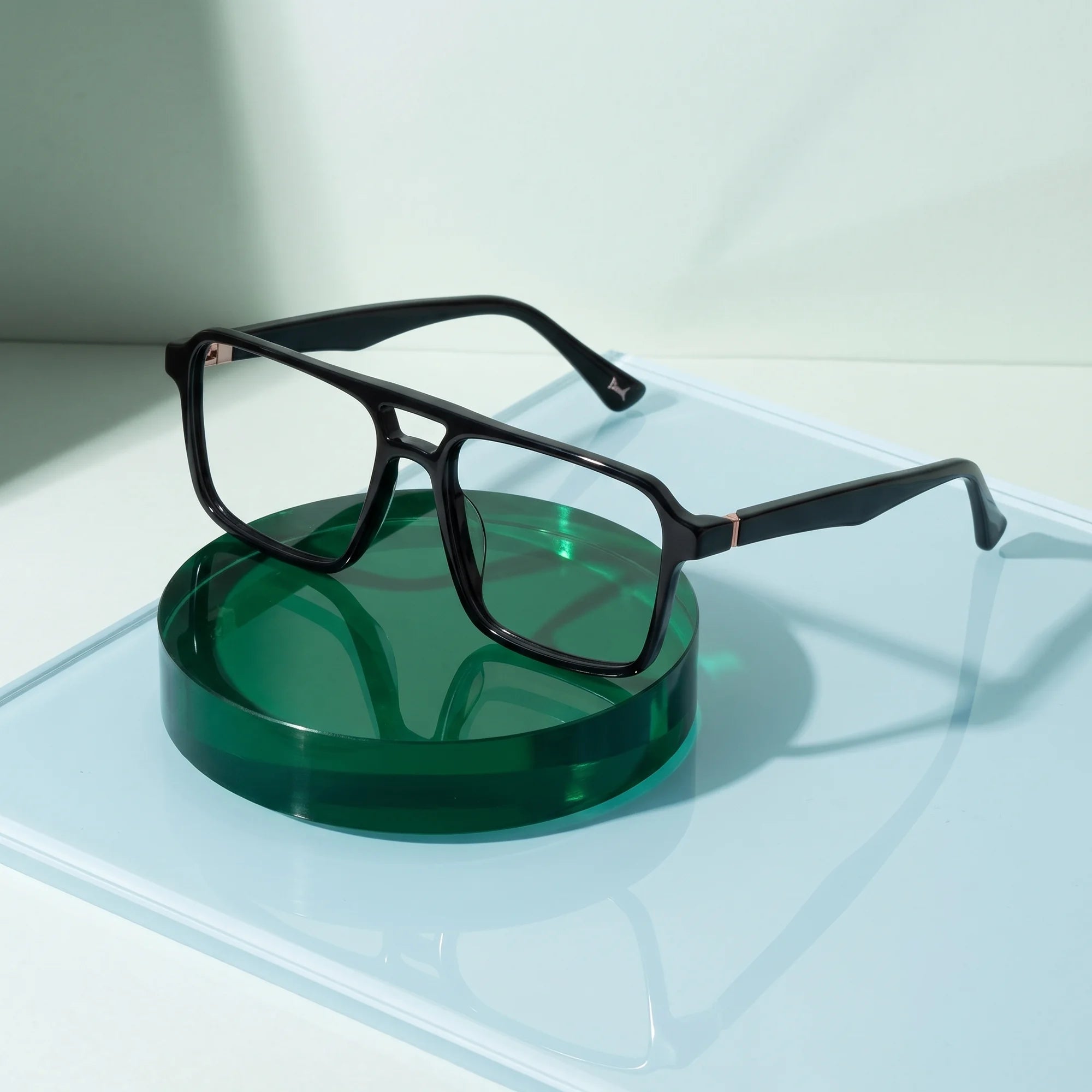 Fiore 1039 eyeglasses in black – on a cobalt acrylic disc in soft daylight
