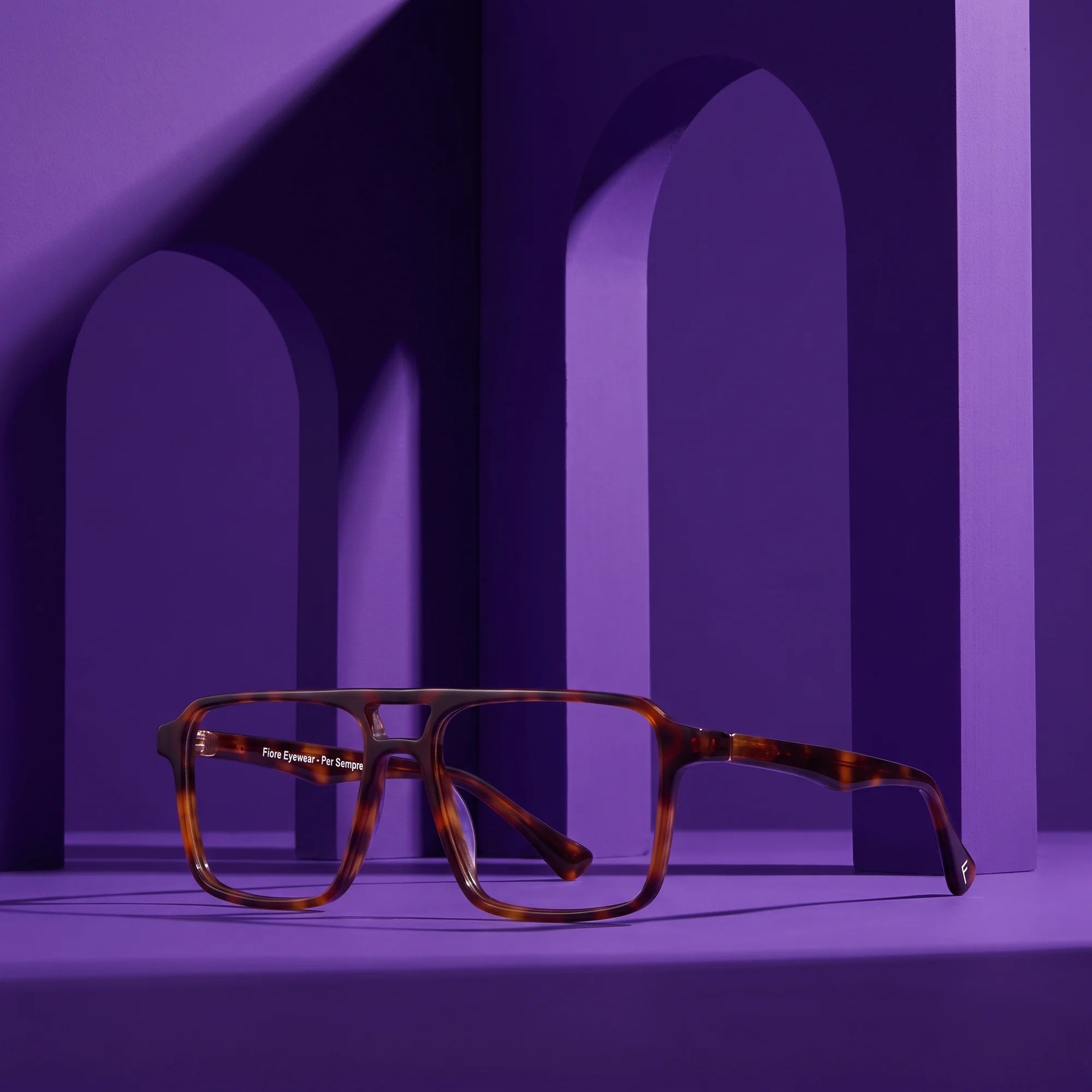Fiore 1039 eyeglasses in tortoiseshell – displayed on a violet podium among arches