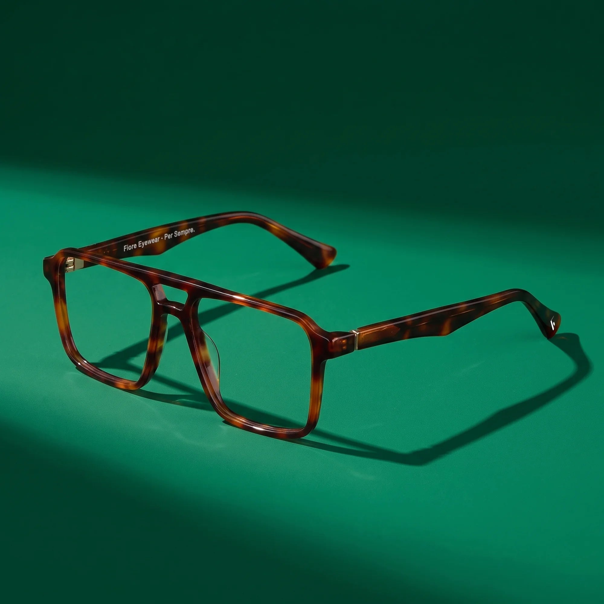 Fiore 1039 eyeglasses in tortoiseshell – editorial still life on a saturated emerald set
