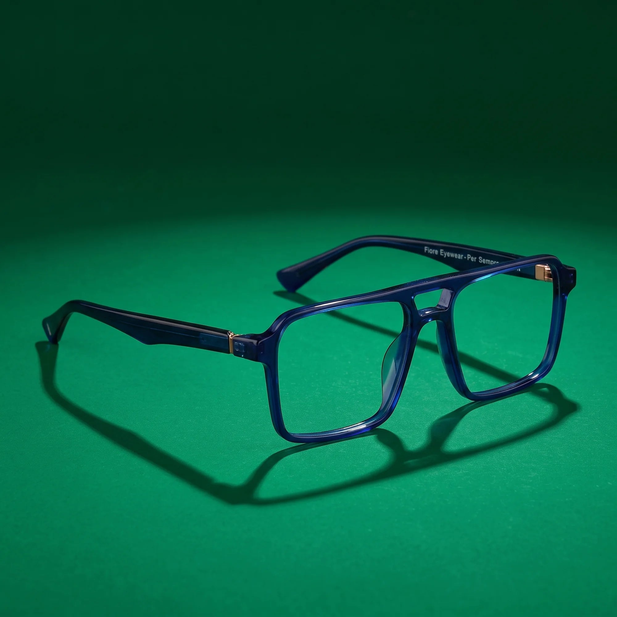 Fiore 1039 eyeglasses in blue – still life on a seamless emerald studio backdrop
