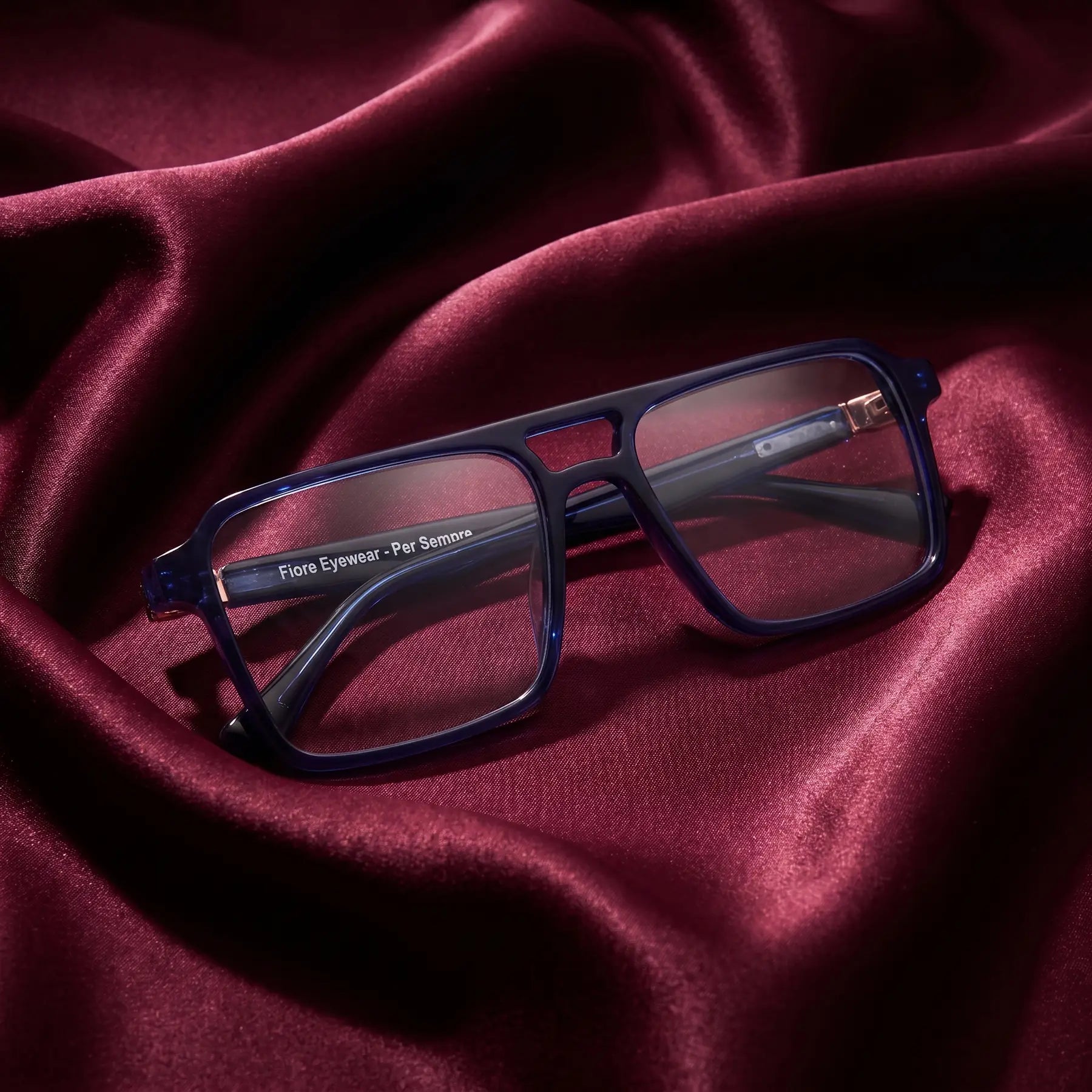 Fiore 1039 eyeglasses in blue – nested in flowing burgundy silk