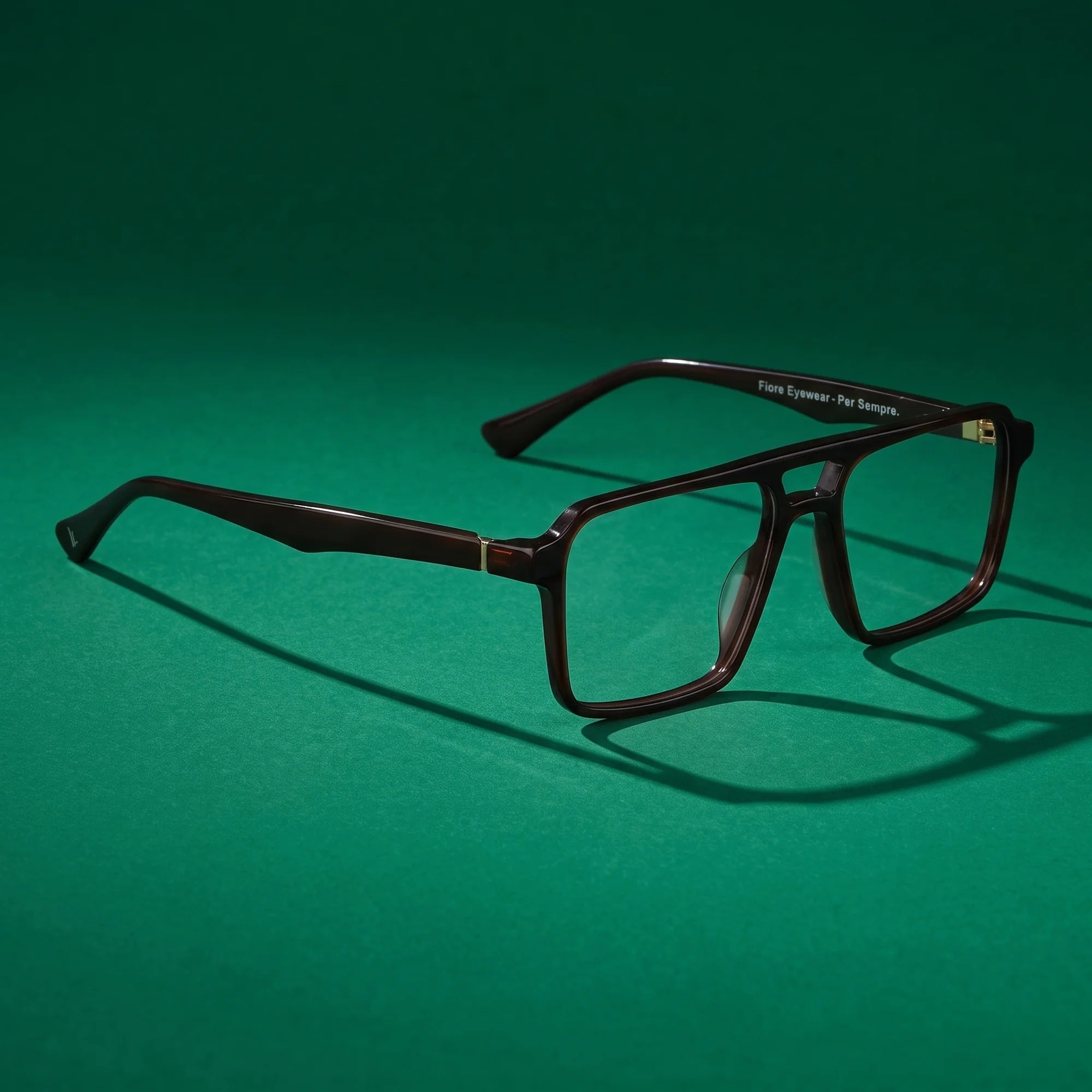 Fiore 1039 eyeglasses in brown – editorial still life on a saturated emerald set