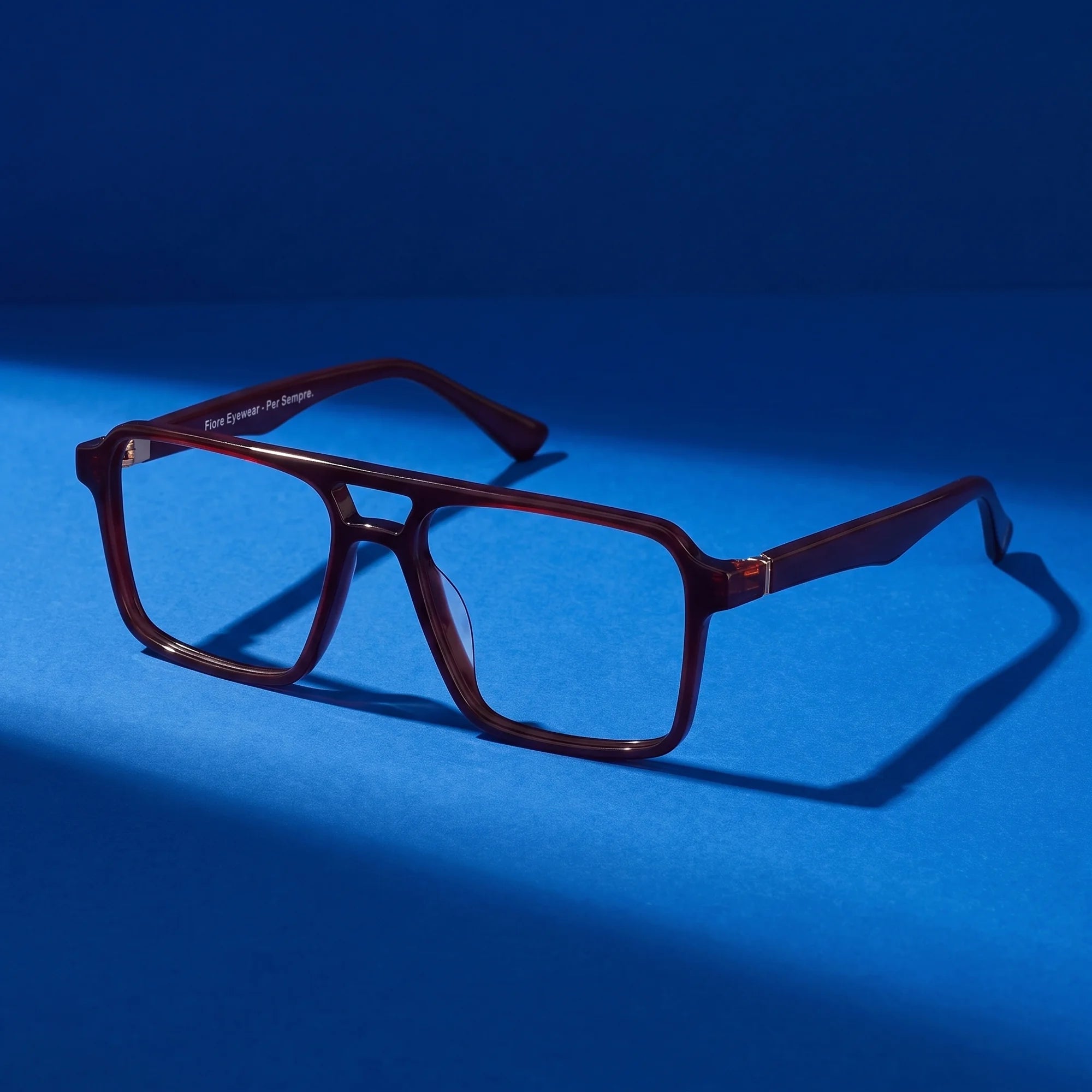 Fiore 1039 eyeglasses in brown – still life on a seamless cobalt studio backdrop