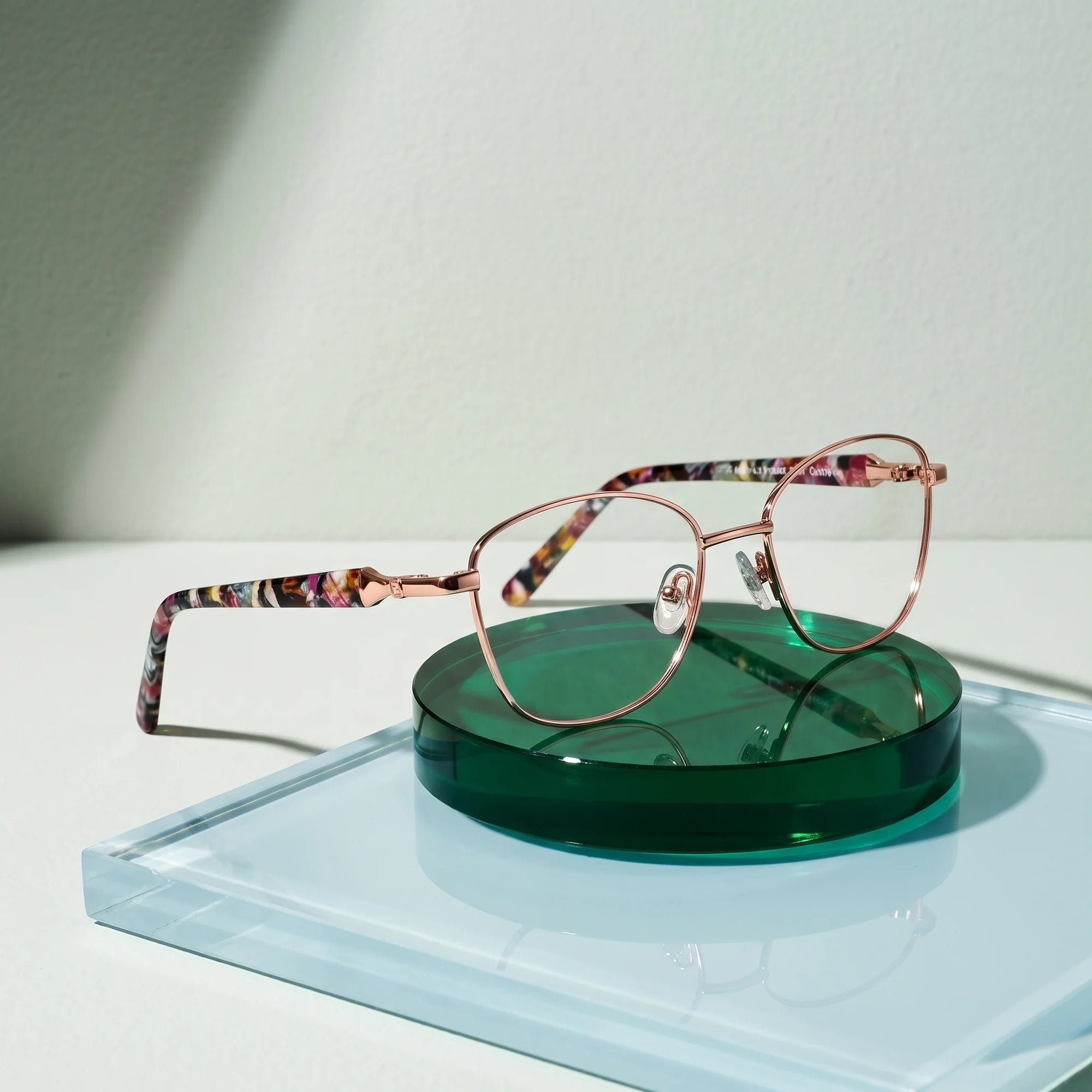 Fiore 2208 eyeglasses in brown gold – on a cobalt acrylic disc in soft daylight