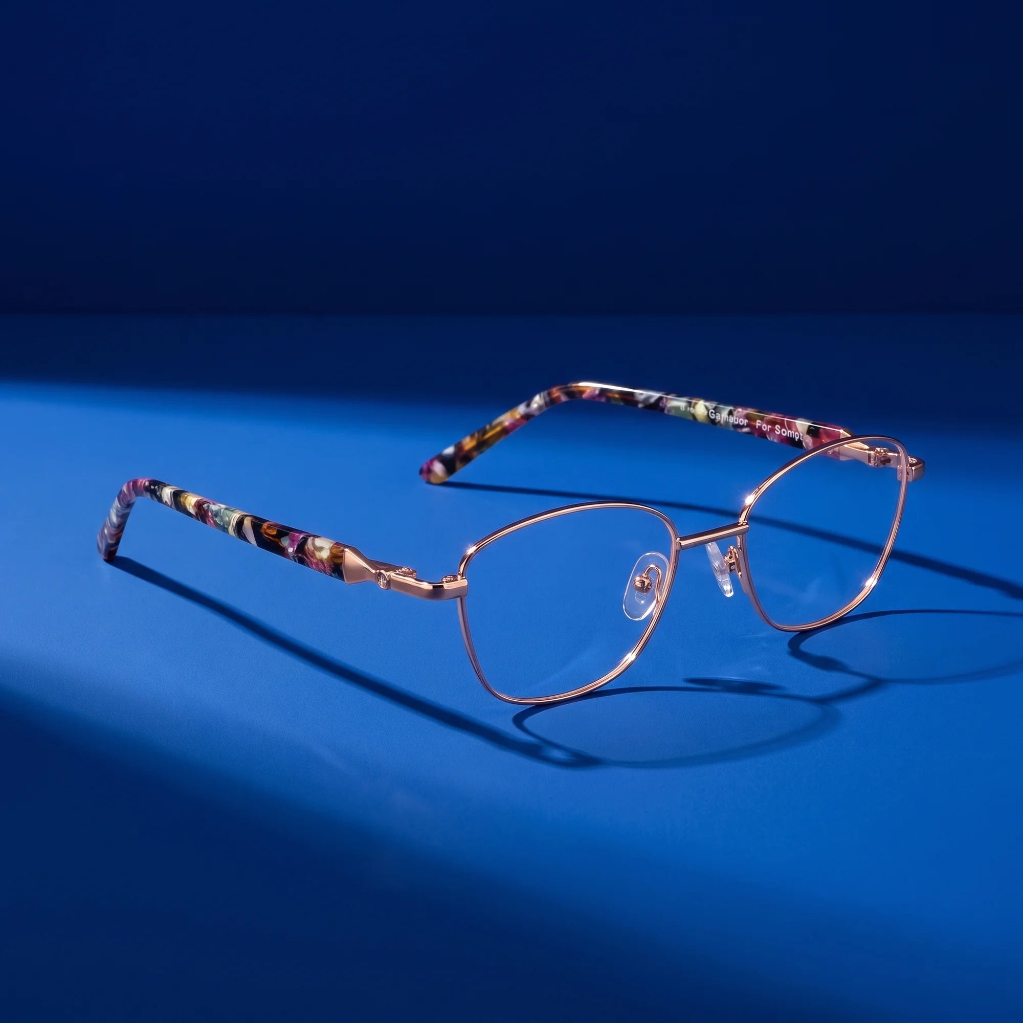 Fiore 2208 eyeglasses in brown gold – hero still life against a deep cobalt backdrop