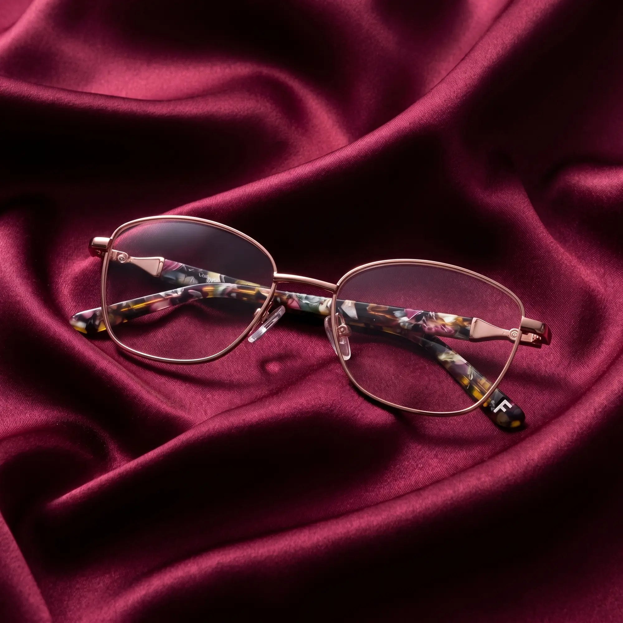 Fiore 2208 eyeglasses in brown gold – nested in flowing burgundy silk